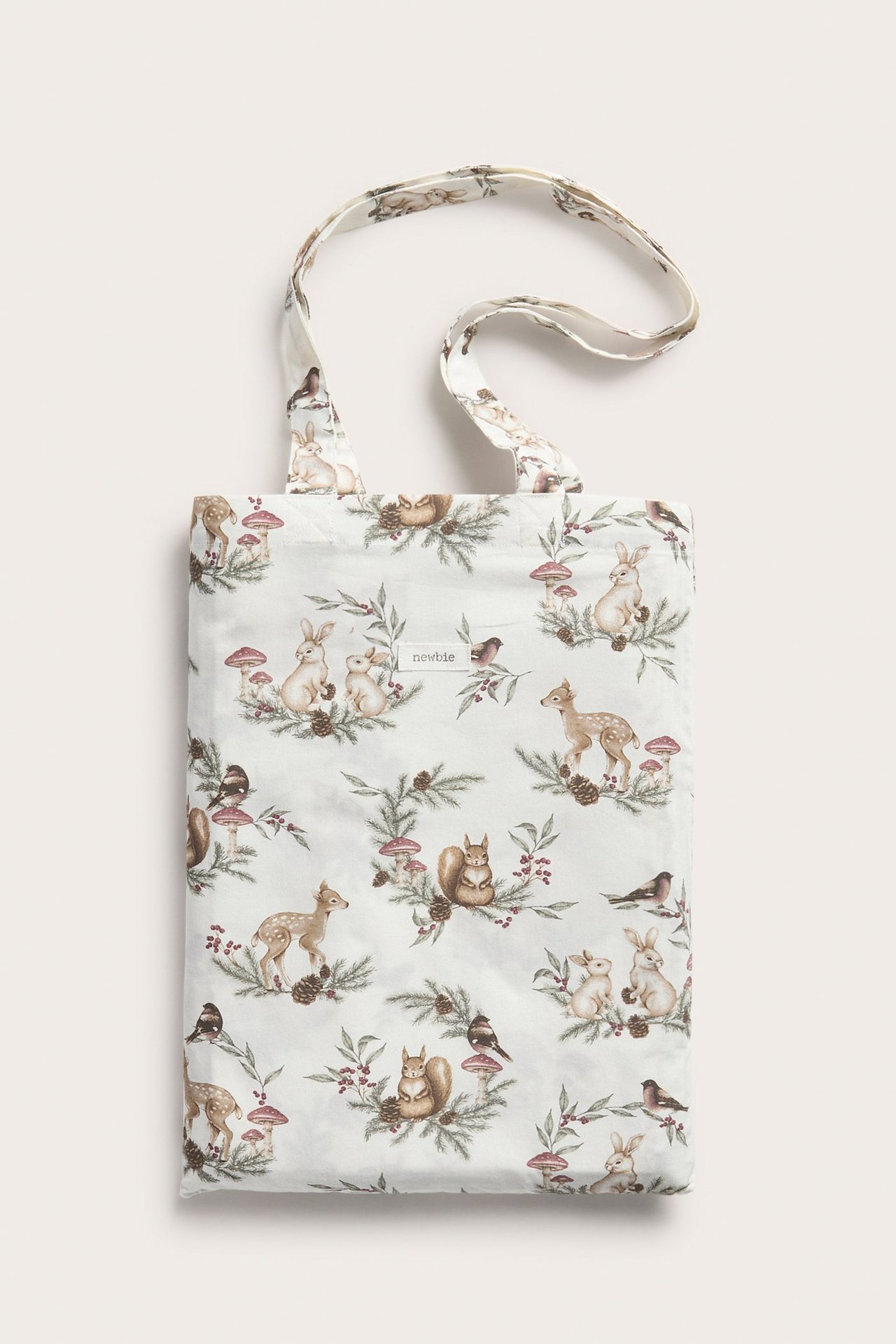 Vorderansicht cremefarbener Baumwoll-Einkaufstasche mit Winterwaldtiermuster, enthält Bettwäscheset.