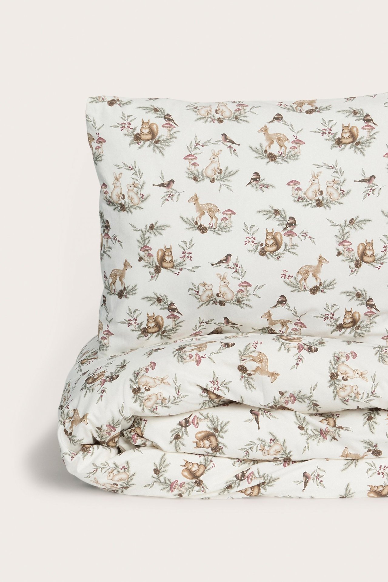 Vorderansicht eines gemusterten Bettwäschesets aus cremefarbener Baumwolle mit Wintertier- und Waldmotiv.