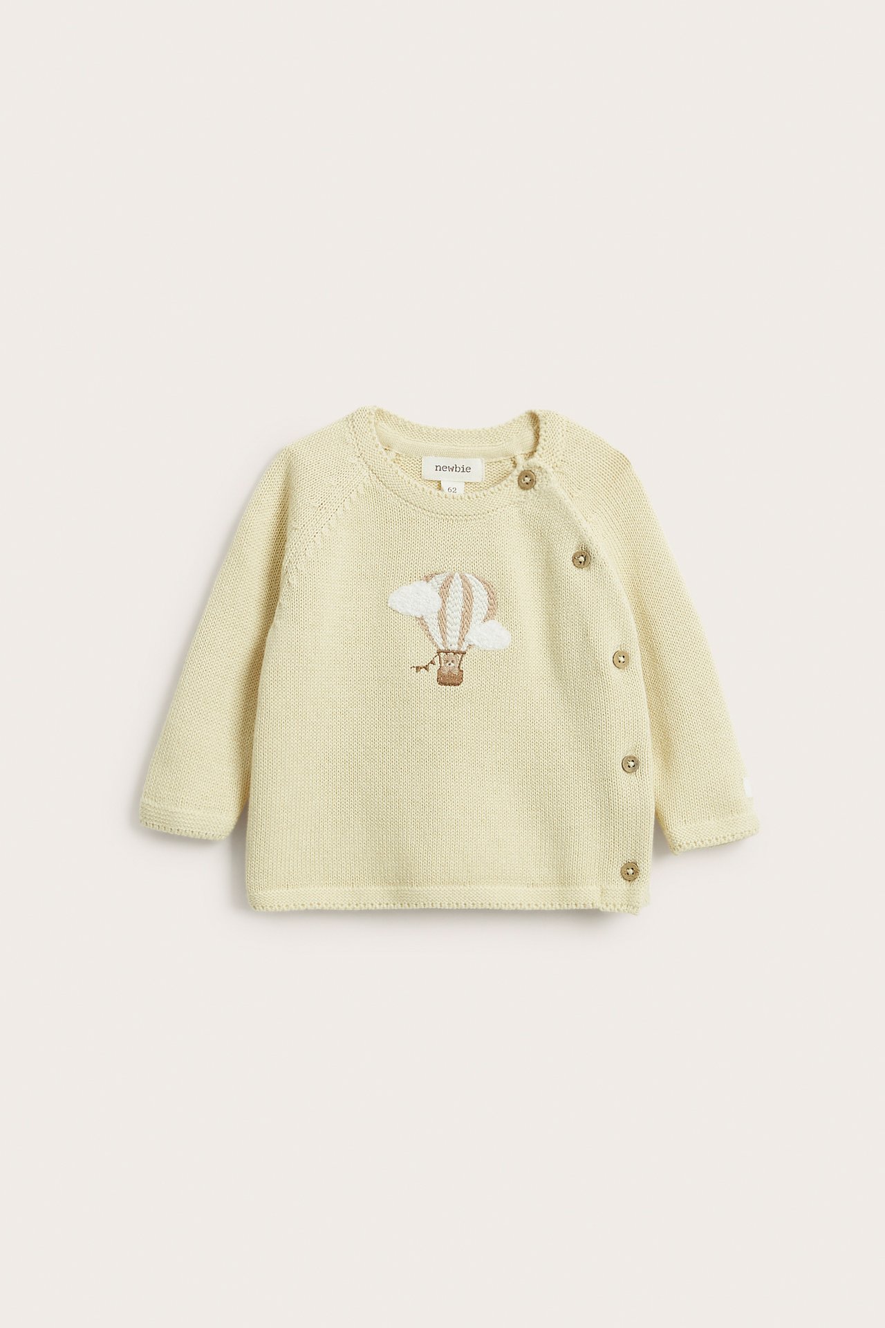 Front view: Baby's light yellow cotton cardigan with hot air balloon embroidery and side buttons.