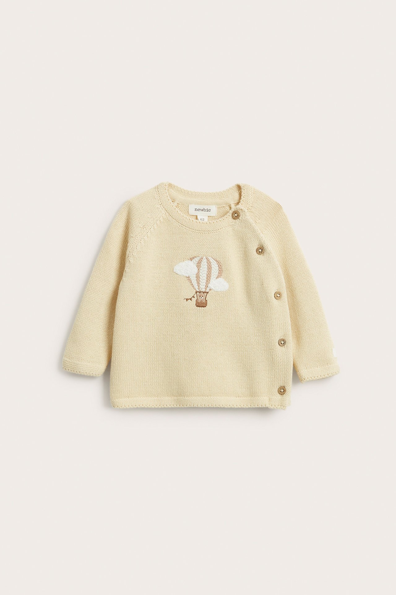 Front view of a baby's light yellow fine-knit cotton cardigan with a hot air balloon embroidery and side buttons.