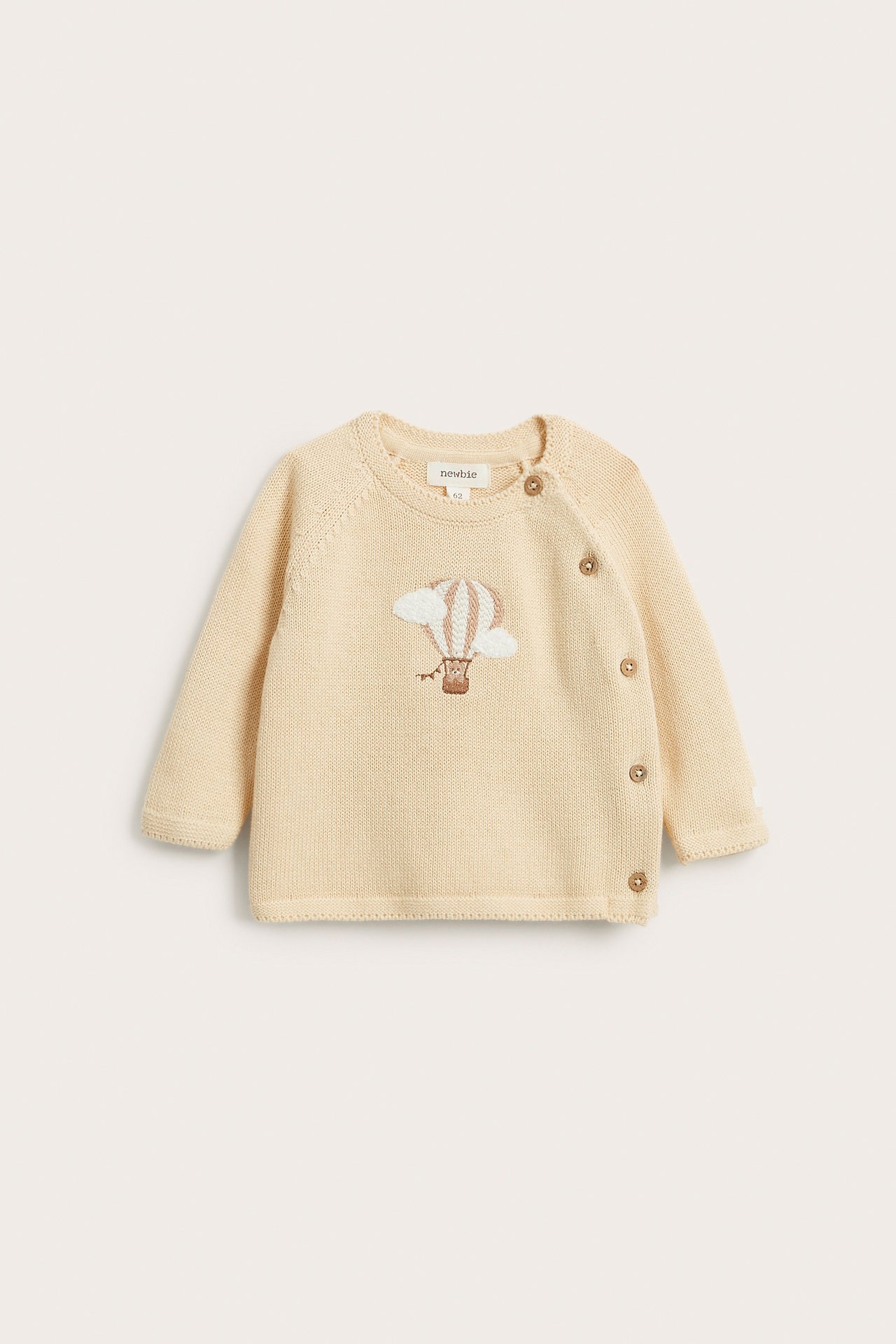 Front view of a baby light yellow knitted cardigan with embroidered hot air balloon and wooden side buttons.