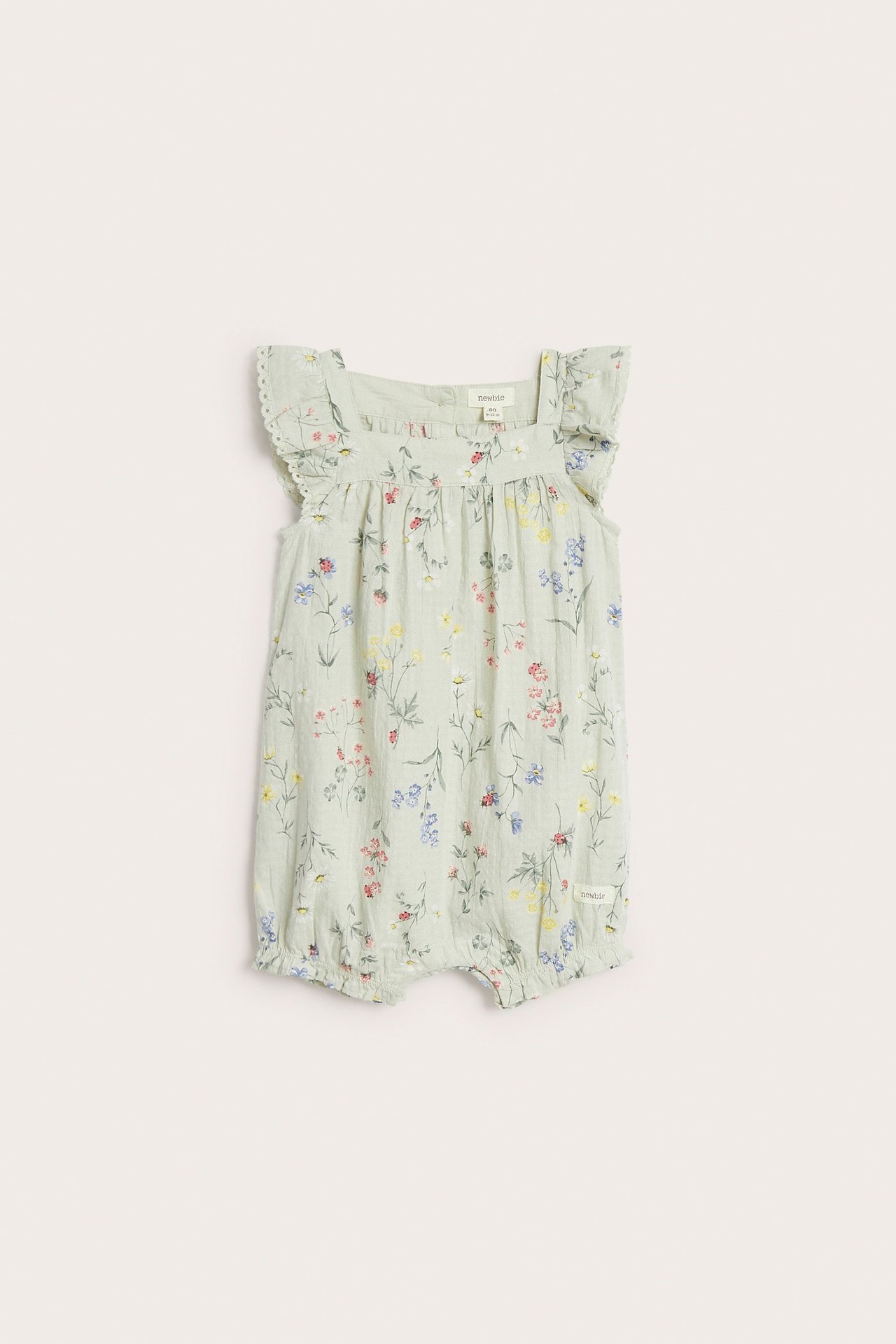 Vorderansicht eines hellgrünen, gewebten Baby-Rompers mit Blumenmuster, Rüschenärmeln, Spitzenkante und Druckknöpfen.