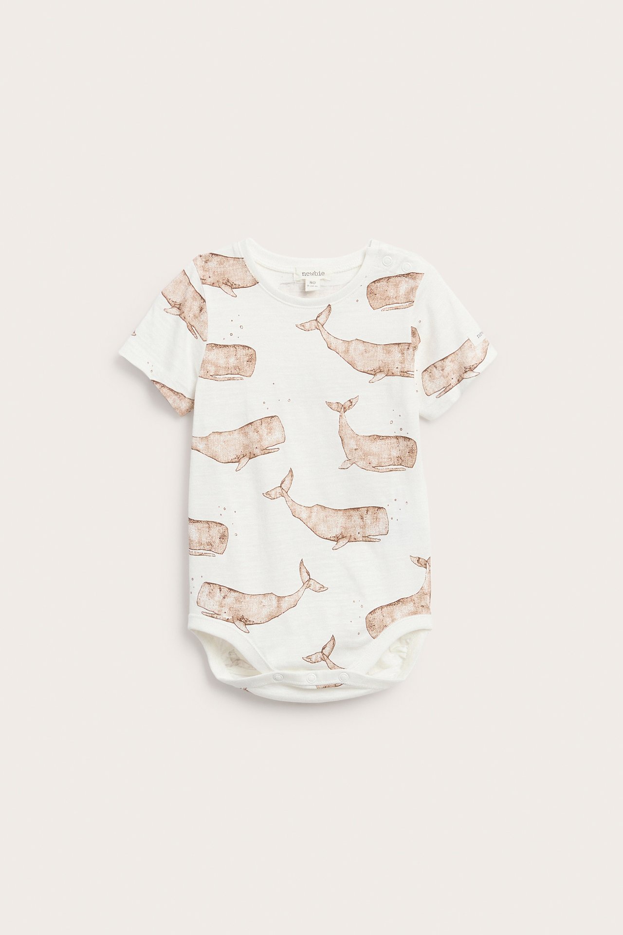 Vorderansicht eines cremefarbenen Baby-Kurzarmbodys aus Baumwolle mit braunem Walmuster und Druckknöpfen.