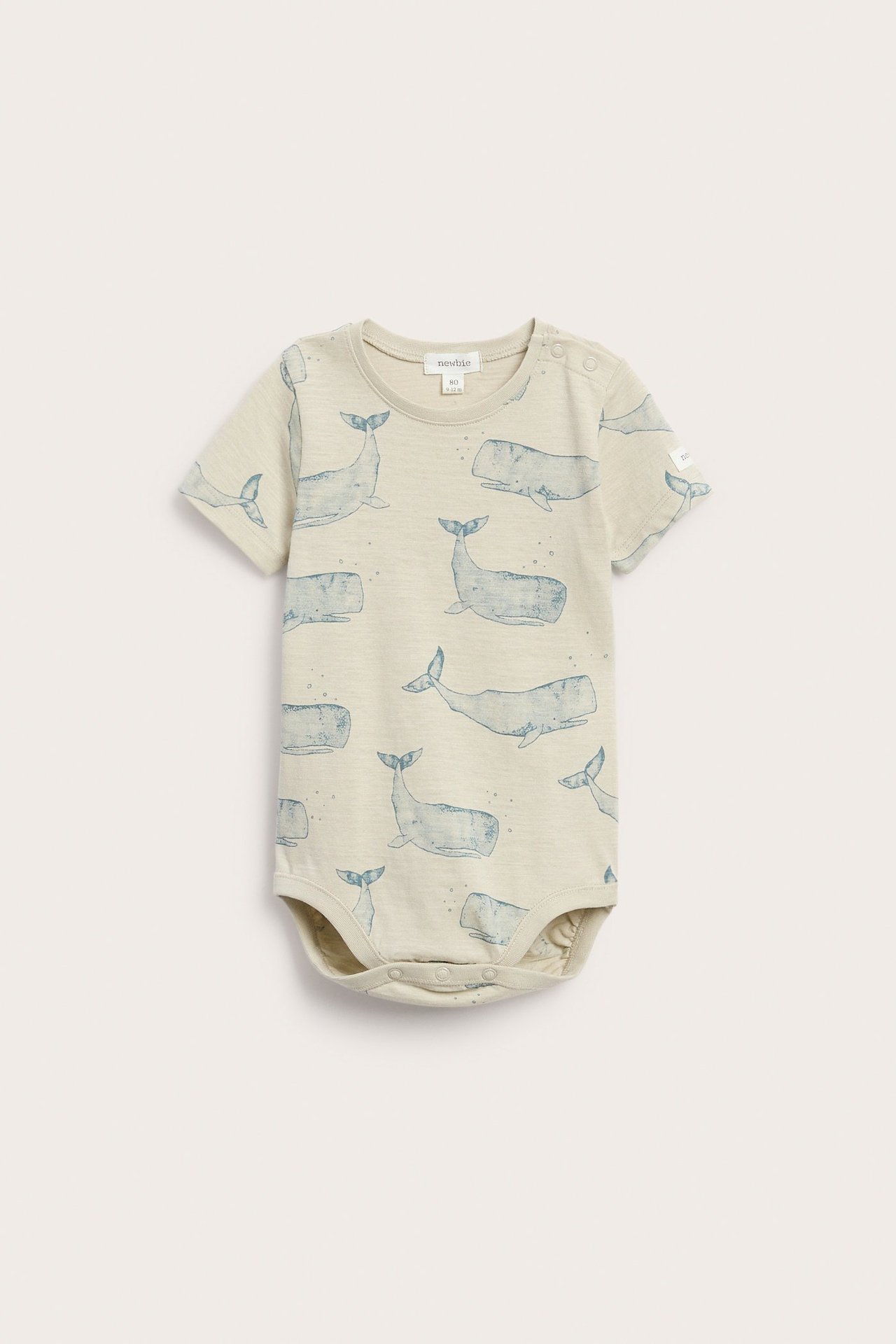 Vorderansicht: beige kurzärmeliger Baby-Body aus Baumwoll-Slubjersey mit blauem Walmuster und Druckknöpfen.