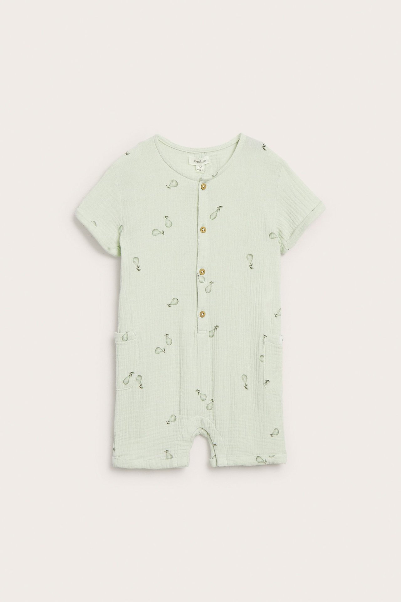 Front view of a light green cotton baby romper with a pear pattern, buttons, and patch pockets.