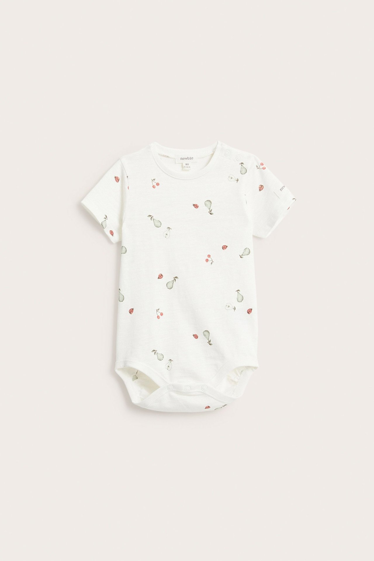 Vorderansicht eines cremeweißen Baby-Kurzarmbodys aus Baumwolle mit Birnen-, Kirsch- und Marienkäfermuster.