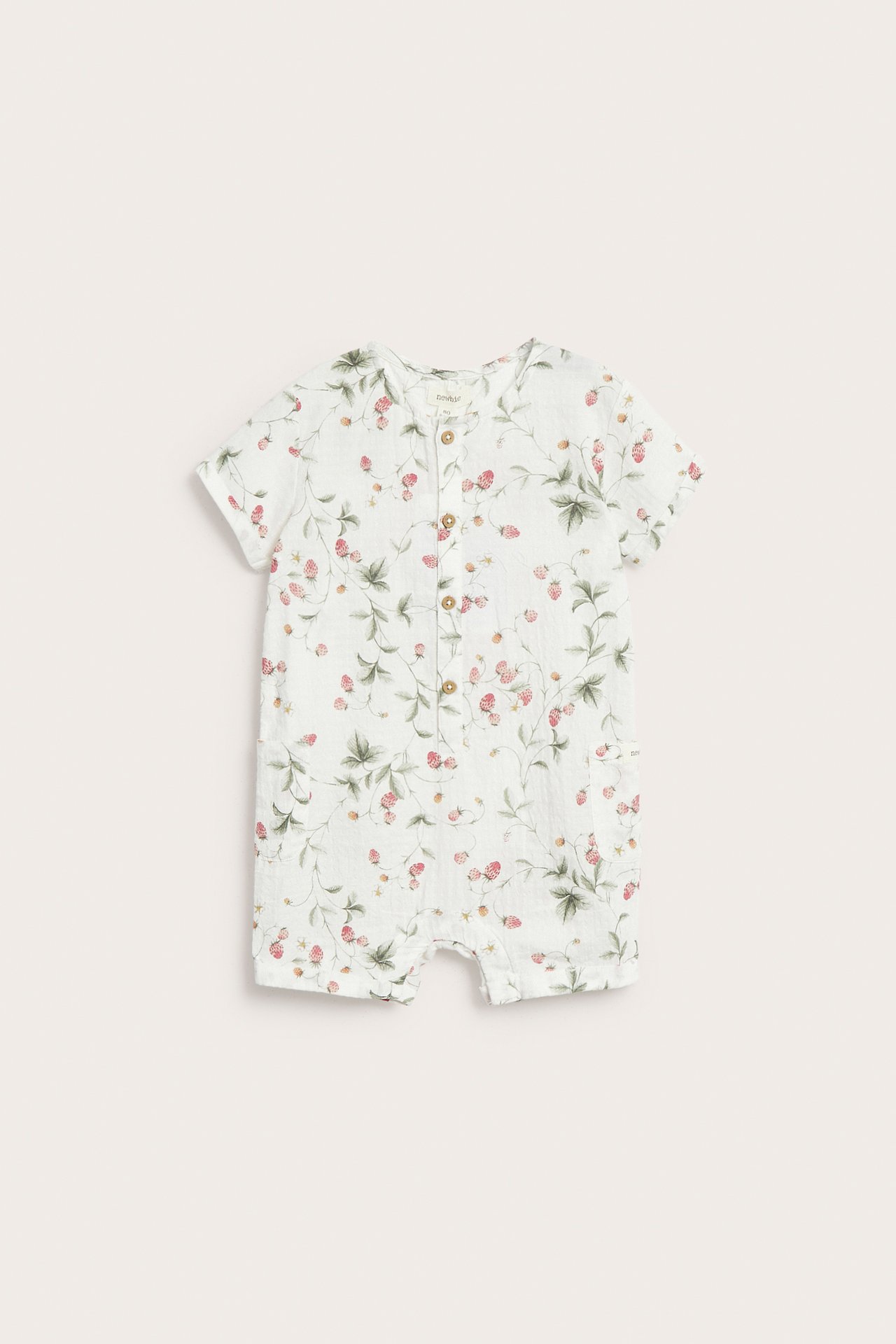 Vorderansicht eines cremefarbenen gewebten Baumwoll-Baby-Rompers mit Erdbeermuster und Holzknöpfen vorne.