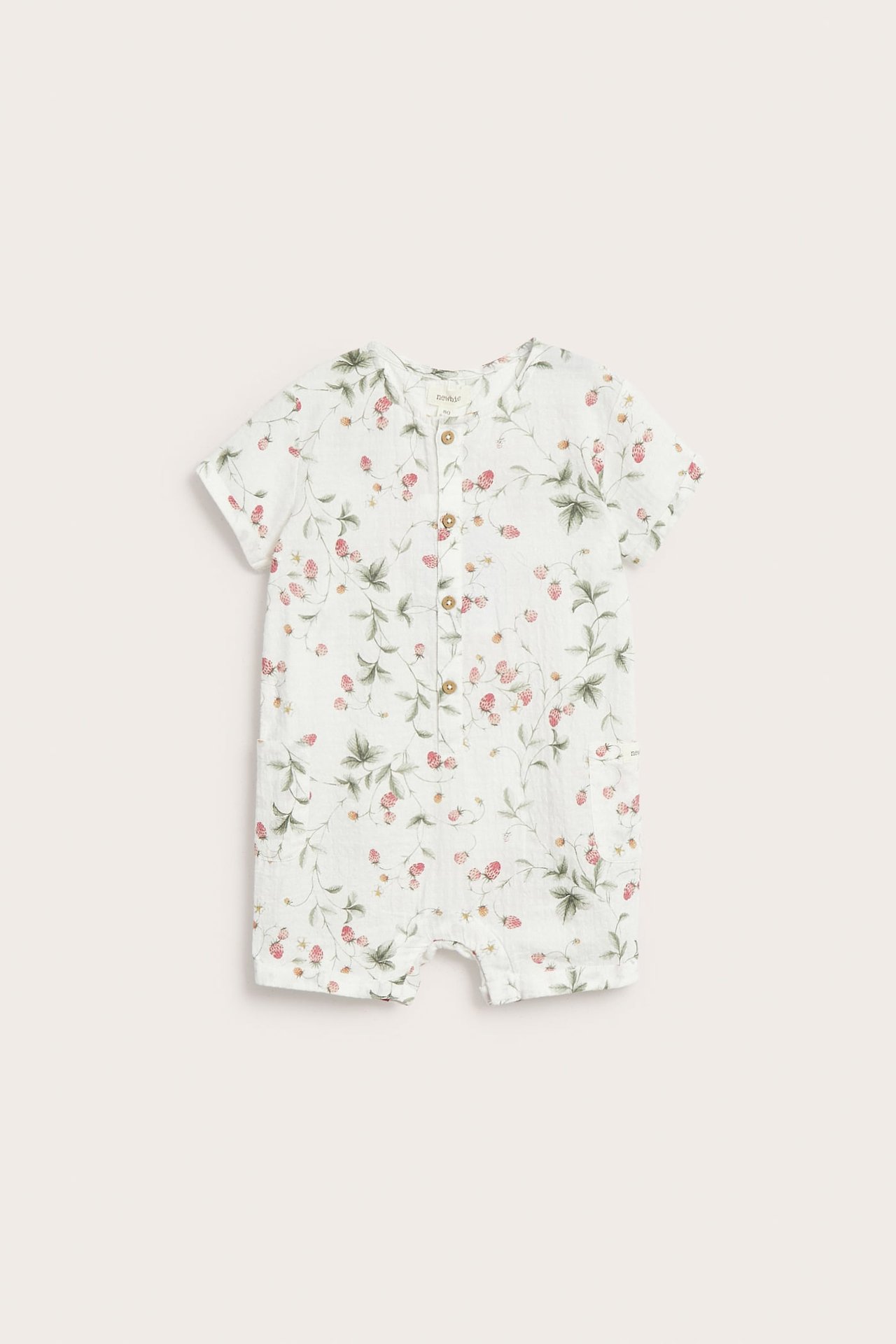 Vorderansicht eines cremefarbenen gewebten Baumwoll-Baby-Rompers mit Erdbeermuster und Holzknöpfen vorne.