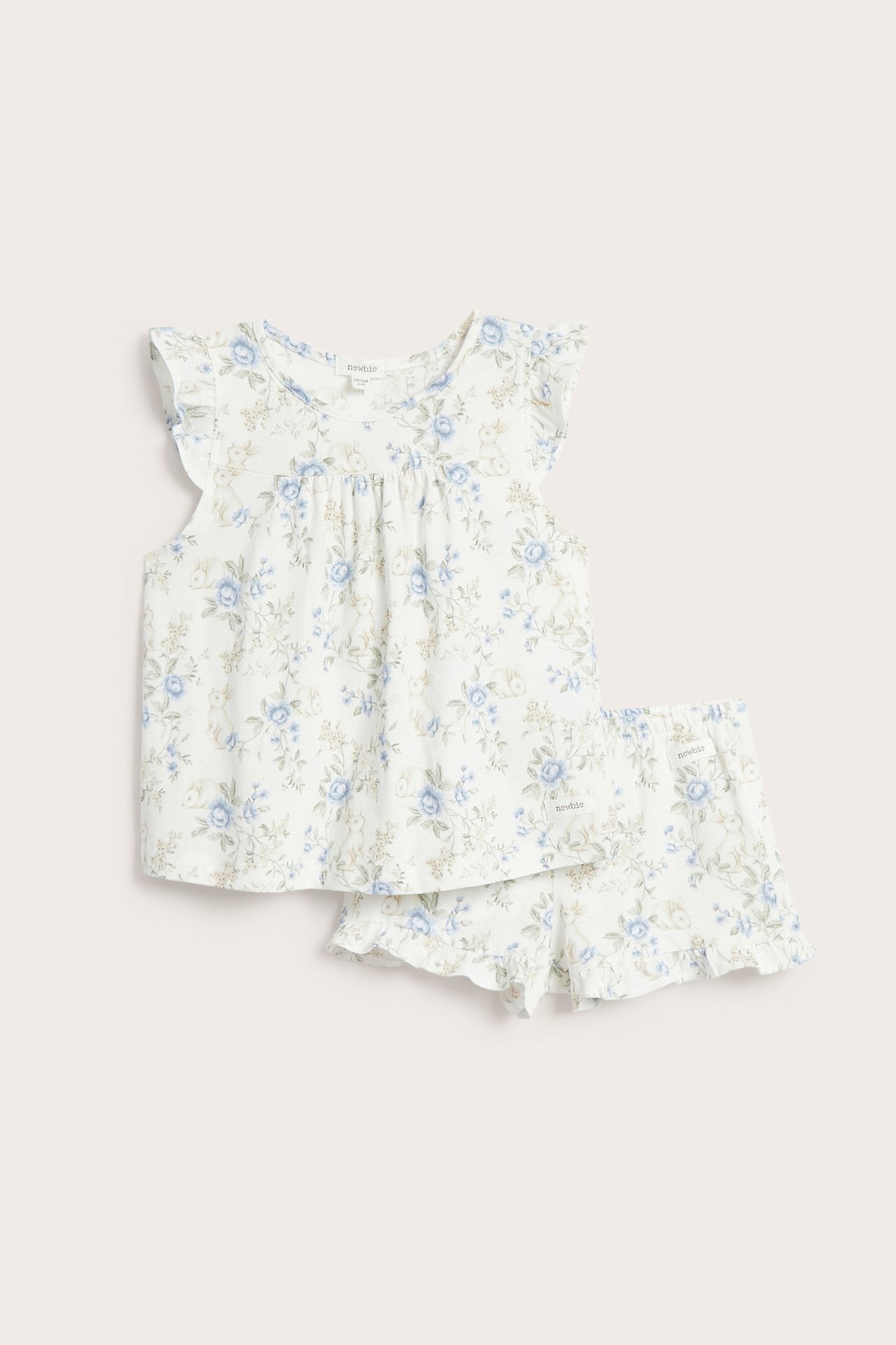 Front view: off-white baby pyjamas set with blue floral and rabbit print, ruffle sleeves and shorts.