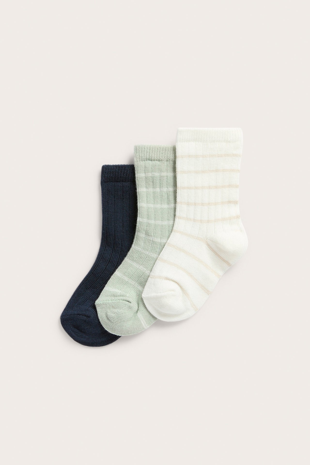 Top view of three ribbed baby socks: off-white striped, light green striped, and plain dark blue.