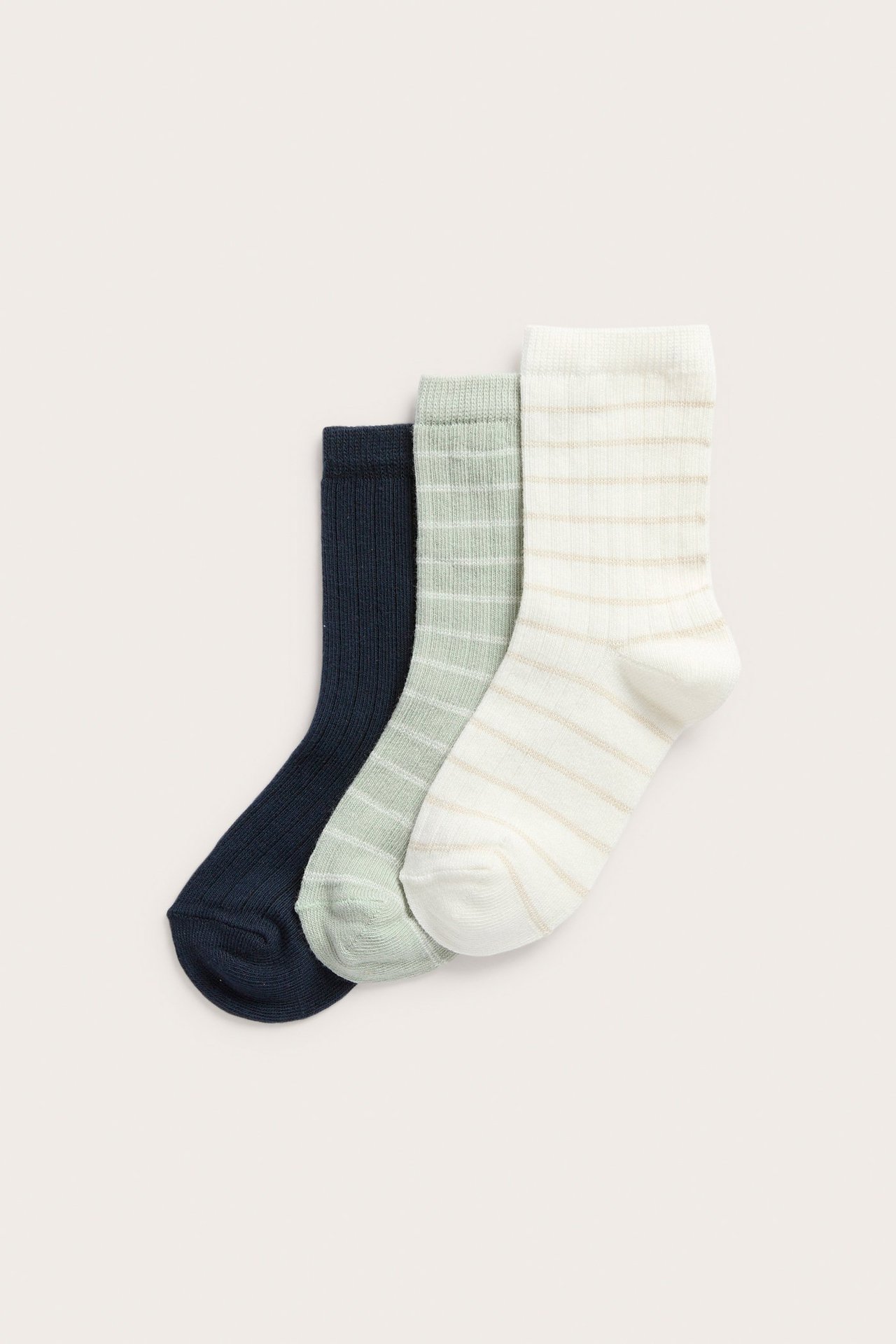 Front view of three pairs of ribbed socks: off-white striped, light green striped, and solid navy.