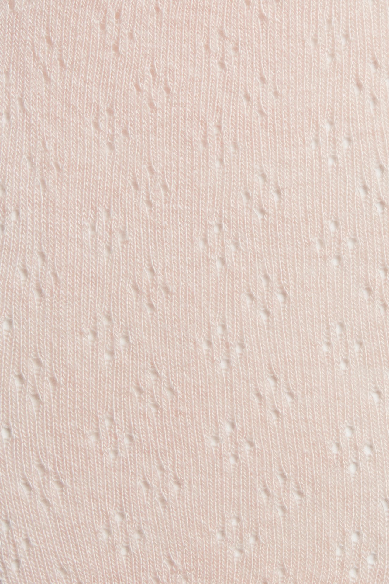 Close-up of light pink knitted tights with a pointelle pattern.