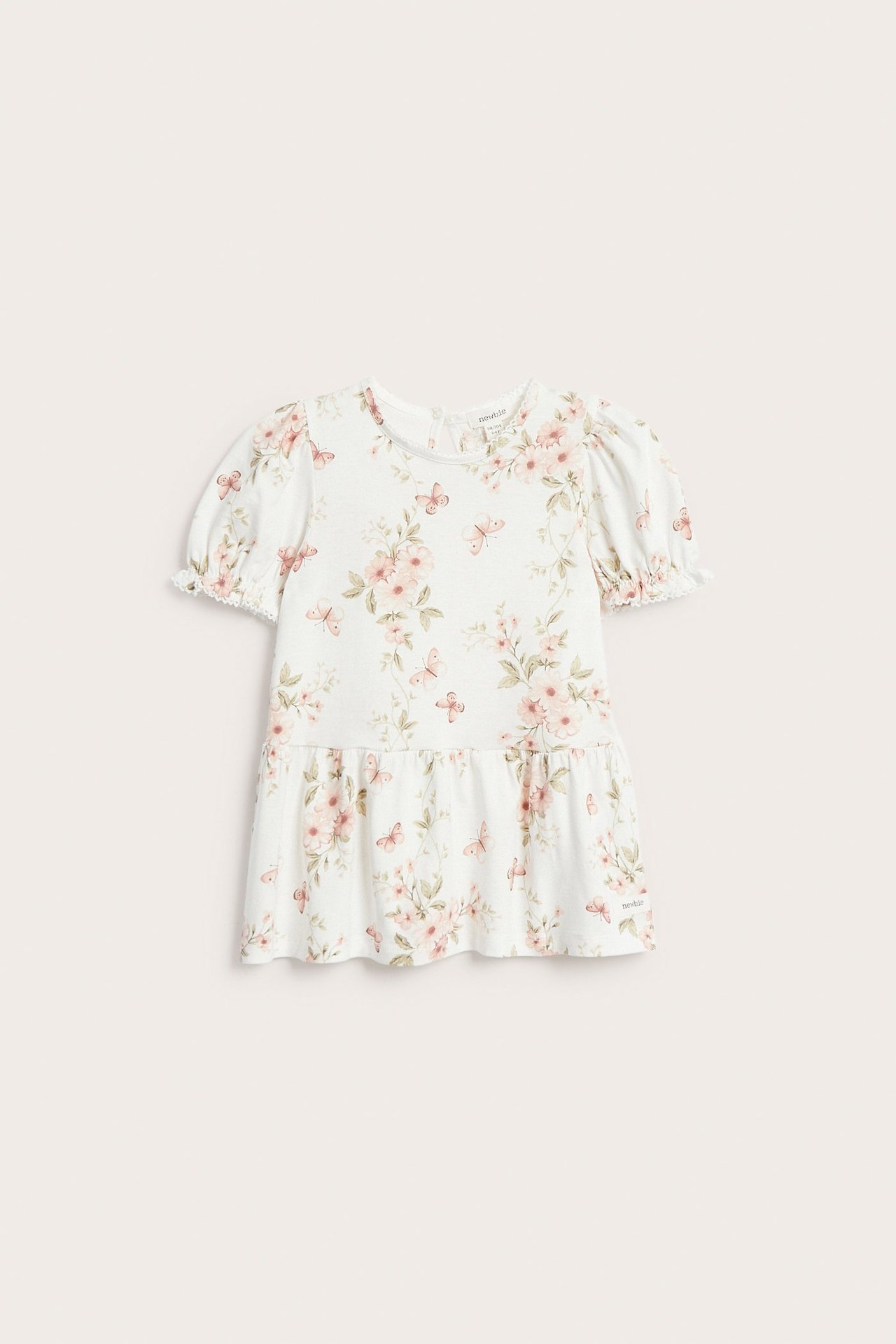 Vorderansicht: Offweißes Kinder-Peplum-Top aus Jersey mit Puffärmeln, Blumen- und Schmetterlingsmuster, Knopf hinten.