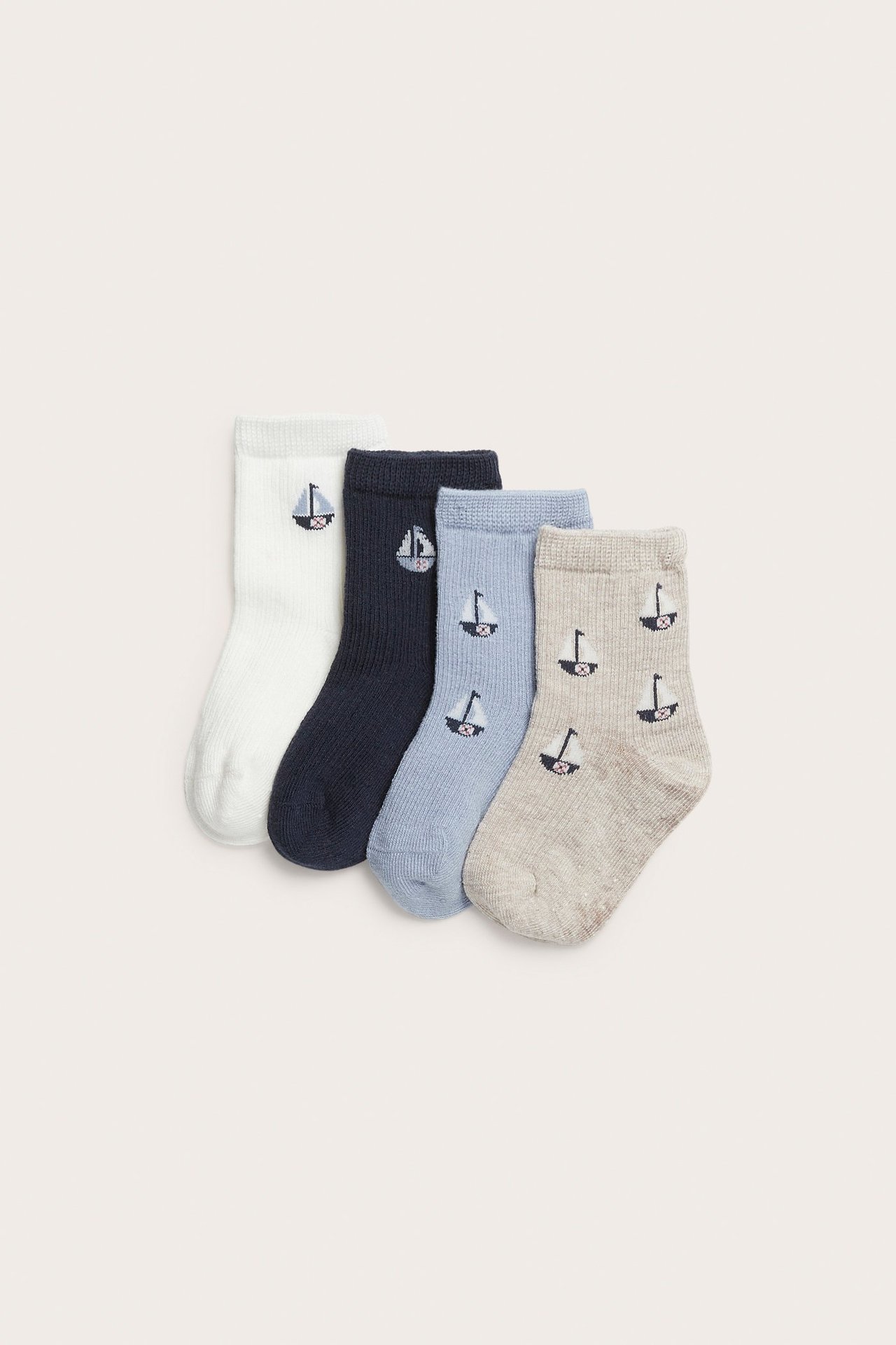 Vorderansicht von vier Paar Babysocken in Weiß, Dunkelblau, Hellblau und Beige, alle mit Segelbootmuster.