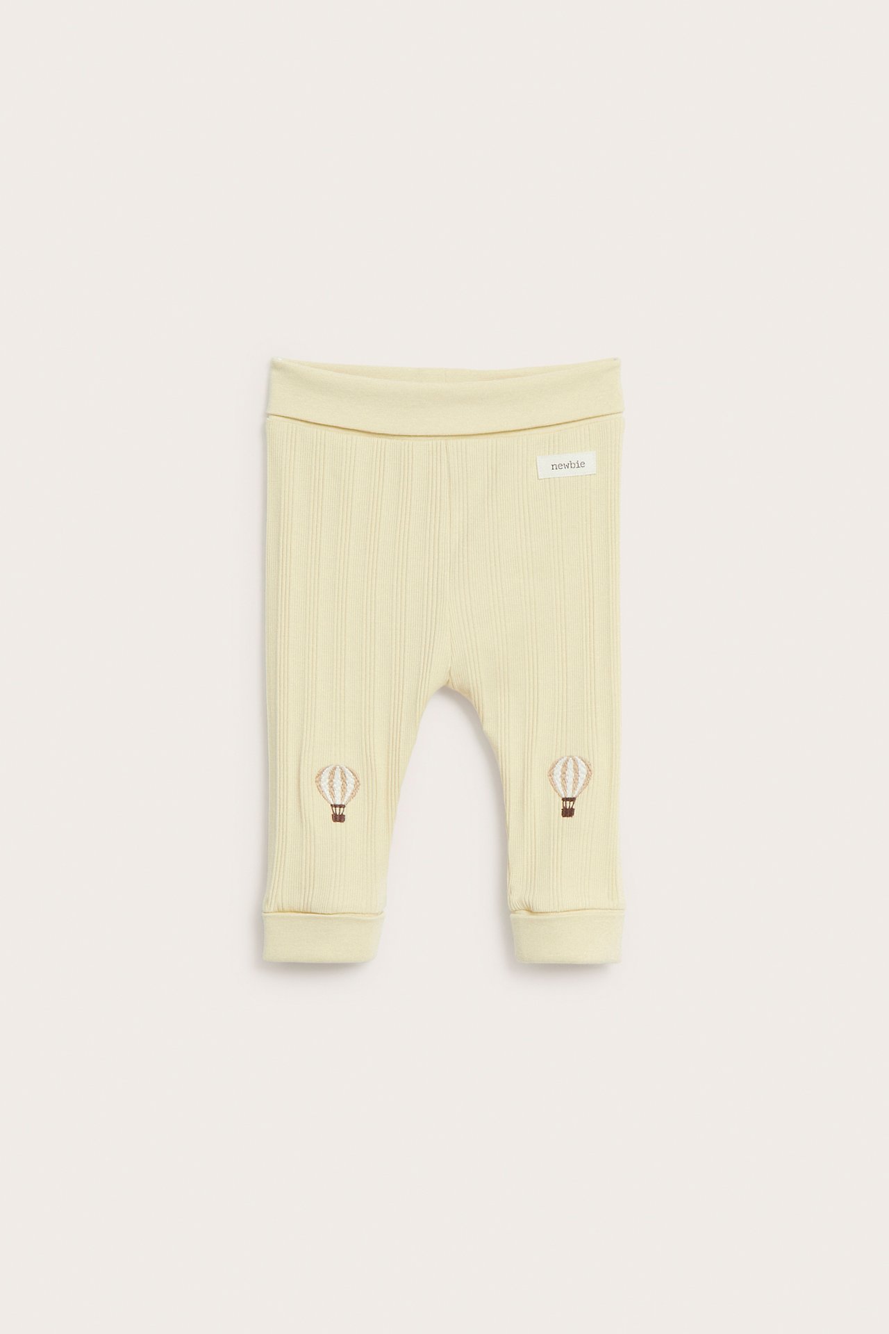 Vorderansicht blassgelber gerippter Baby-Jersey-Leggings mit braunen Heißluftballon-Knieapplikationen und umklappbaren Bündchen.