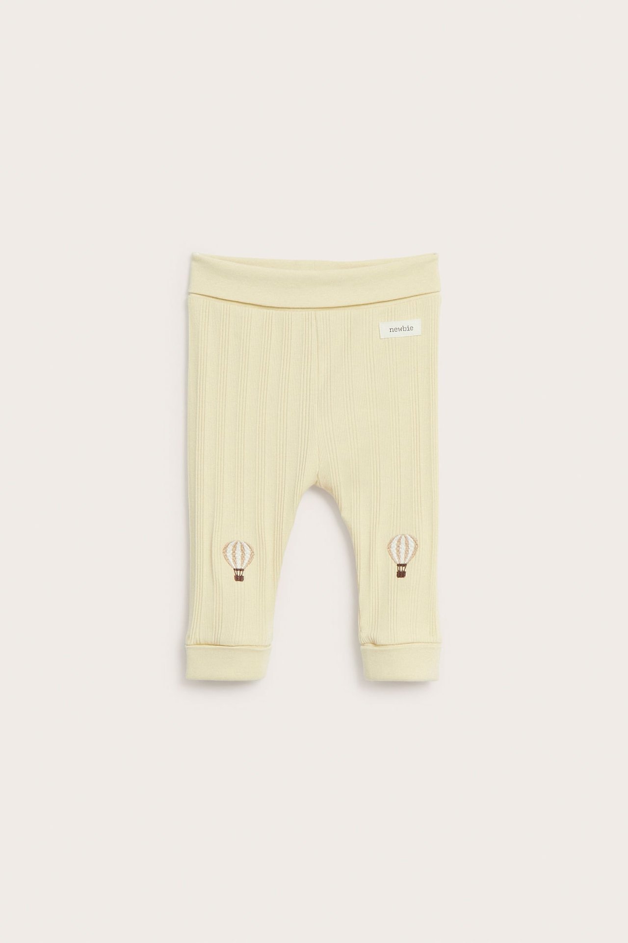 Vorderansicht blassgelber gerippter Baby-Jersey-Leggings mit braunen Heißluftballon-Knieapplikationen und umklappbaren Bündchen.