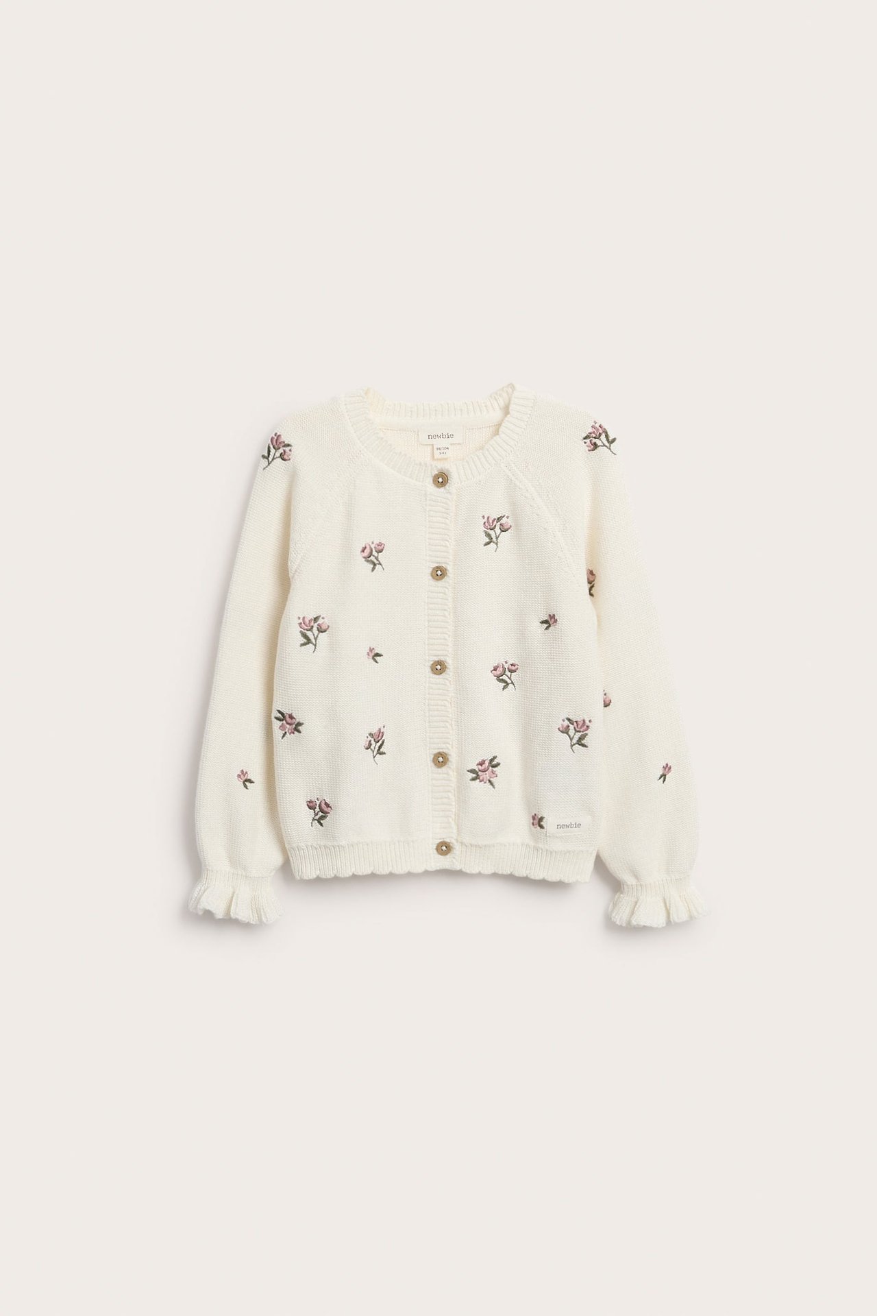 Vorderansicht: Off-white Baumwoll-Strickjacke mit gestickten rosa Blumen, Holzknöpfen und gerippten Wellenrand-Bündchen.