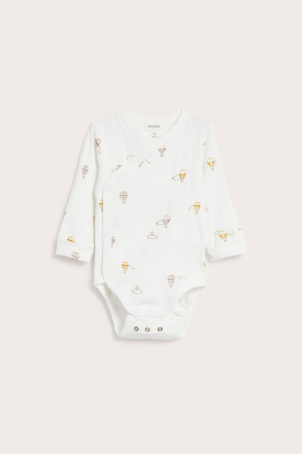 Front view: Off-white ribbed baby wrap bodysuit with hot air balloon print, long sleeves, and snap crotch.