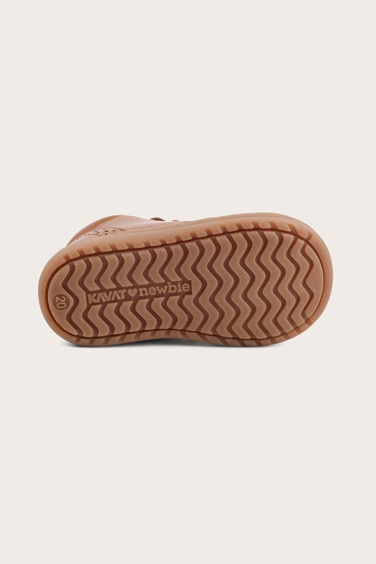Bottom view of a brown baby's walking shoe with a textured, wavy pattern on its sole.