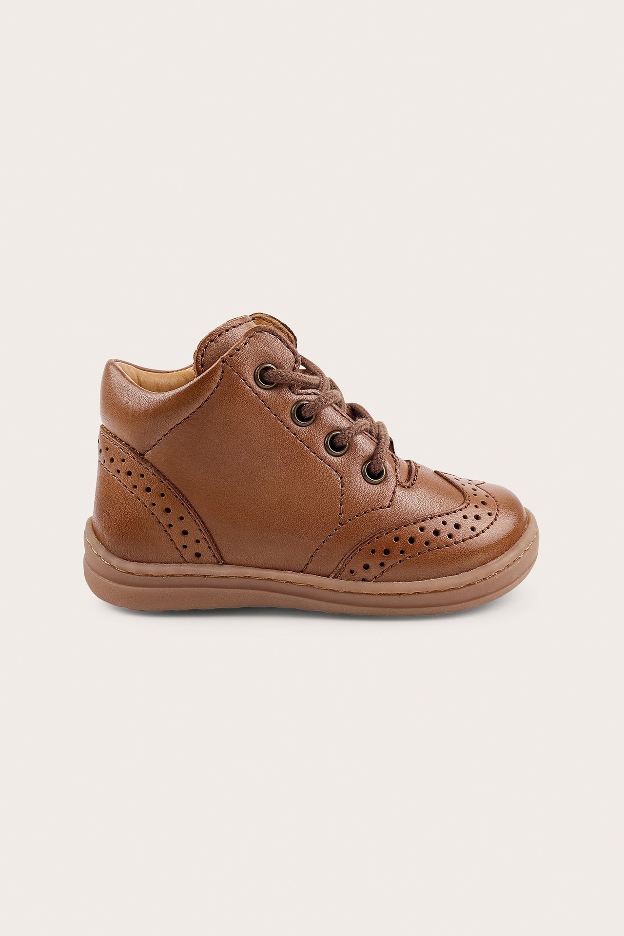 Side view of a brown leather kid's walking shoe with brogue details and brown laces.