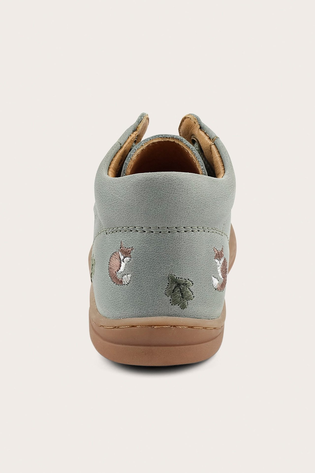 Back view of a green baby first-walker shoe with embroidered foxes and leaves on the side.