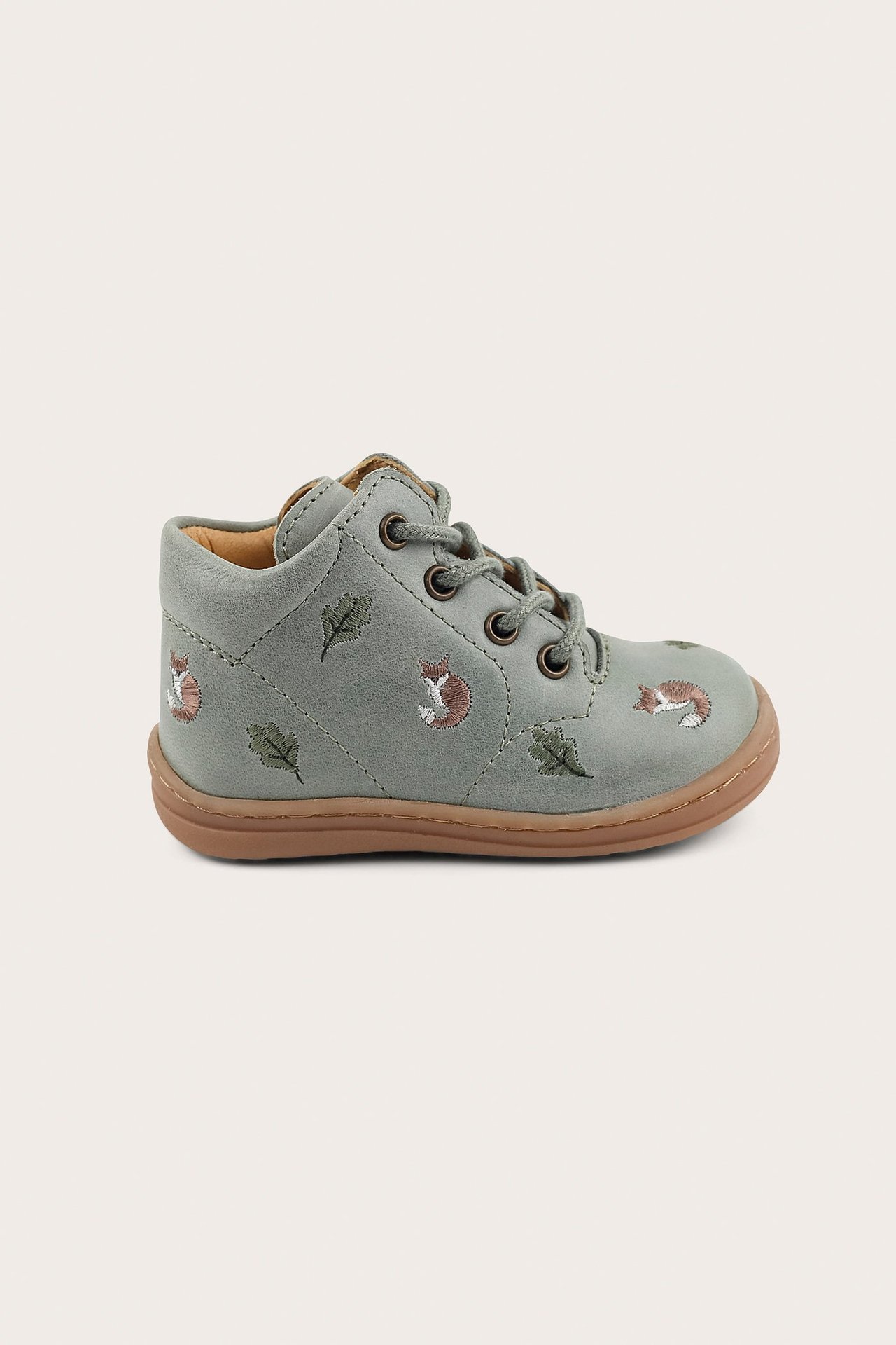 Side view of a green kid's leather first-walker shoe with fox and leaf embroidery, and laces.