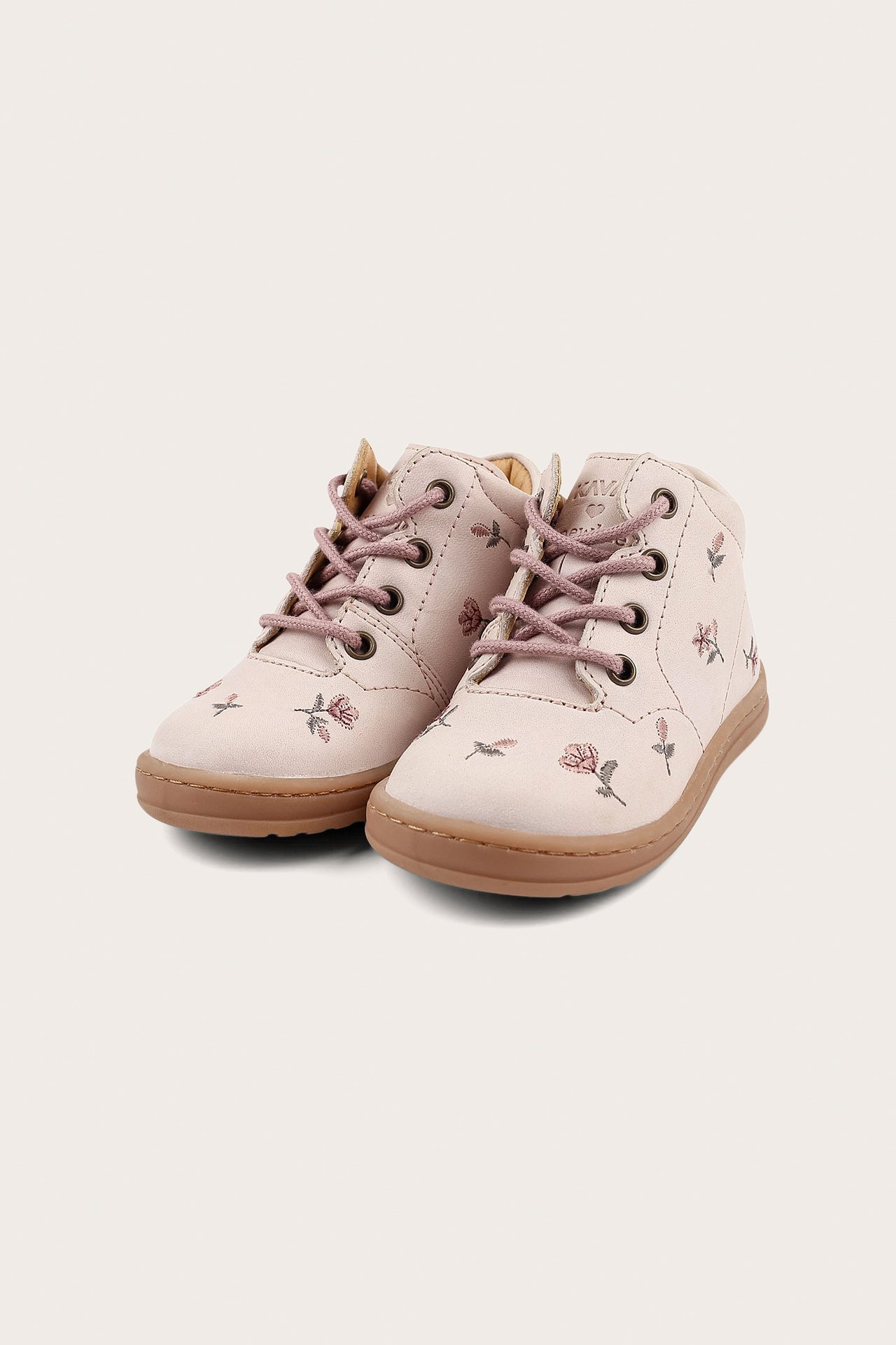 Vorderansicht von hellrosa geblümten Kinder-Schuhen mit rosa Schnürsenkeln und braunen Sohlen.