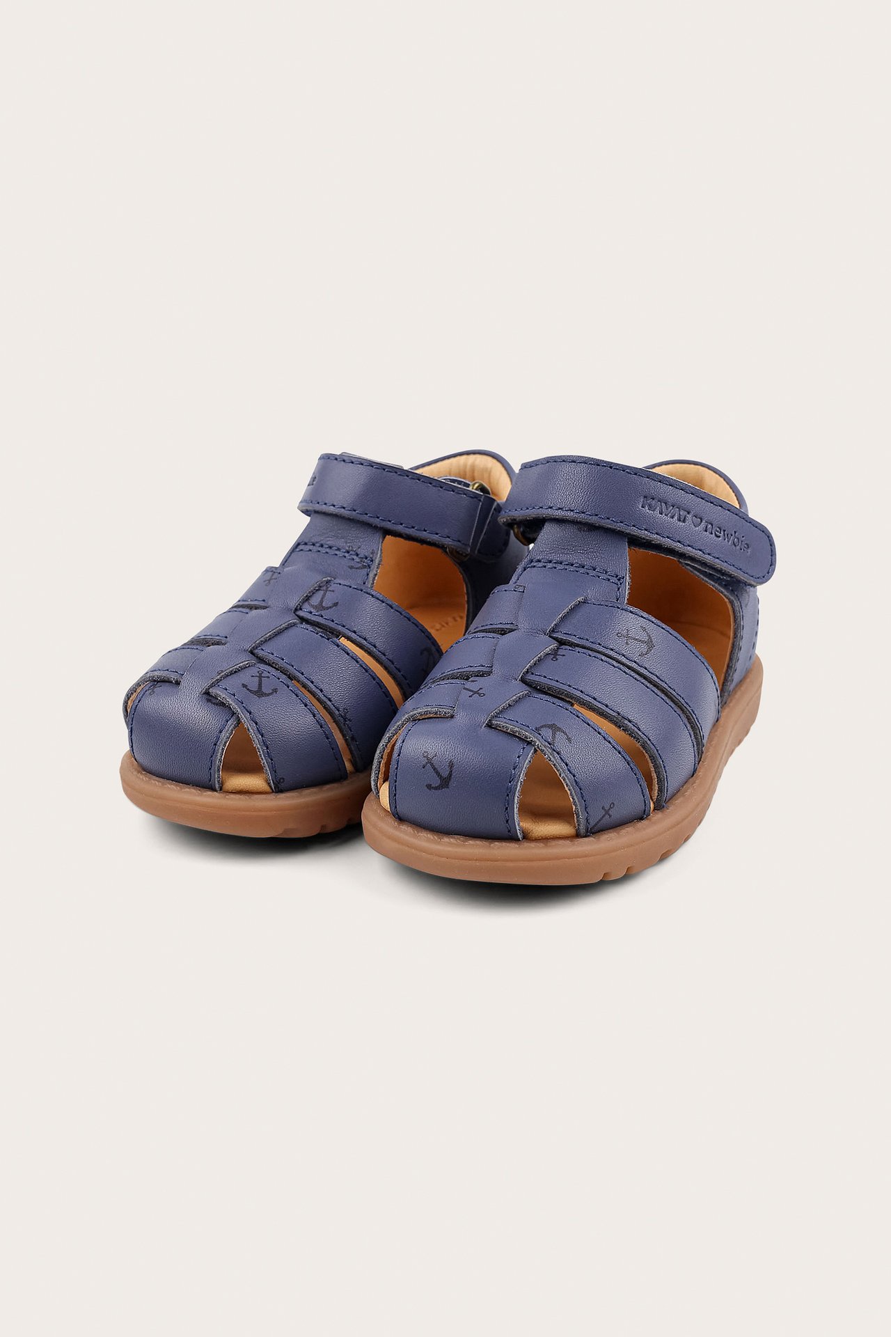 Front-side view of kids' navy blue leather sandals with anchor pattern and hook-and-loop fastening.