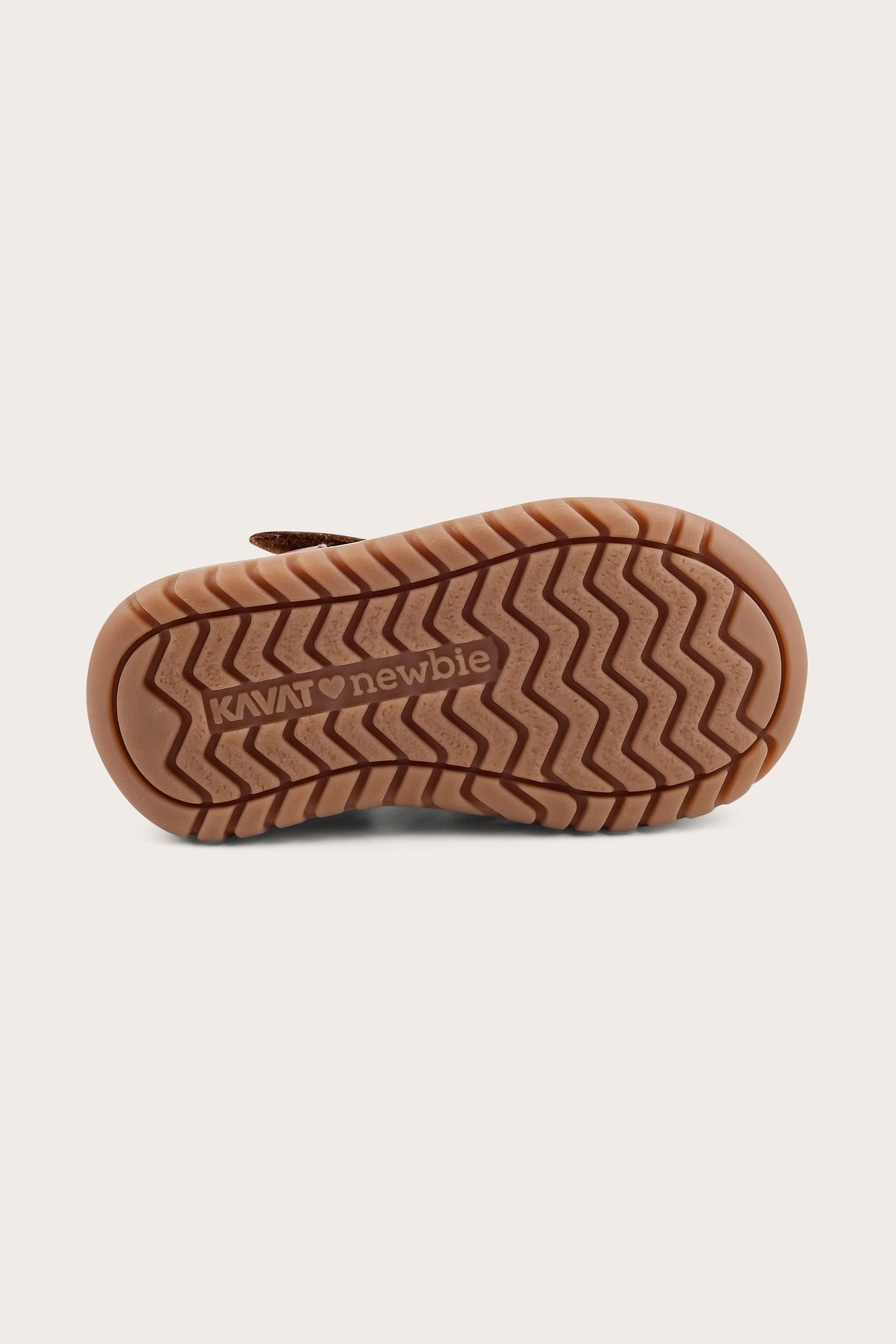 Bottom view of a brown kids' sandal with a textured sole, featuring a zigzag pattern and 'KAVAT newborn' branding.