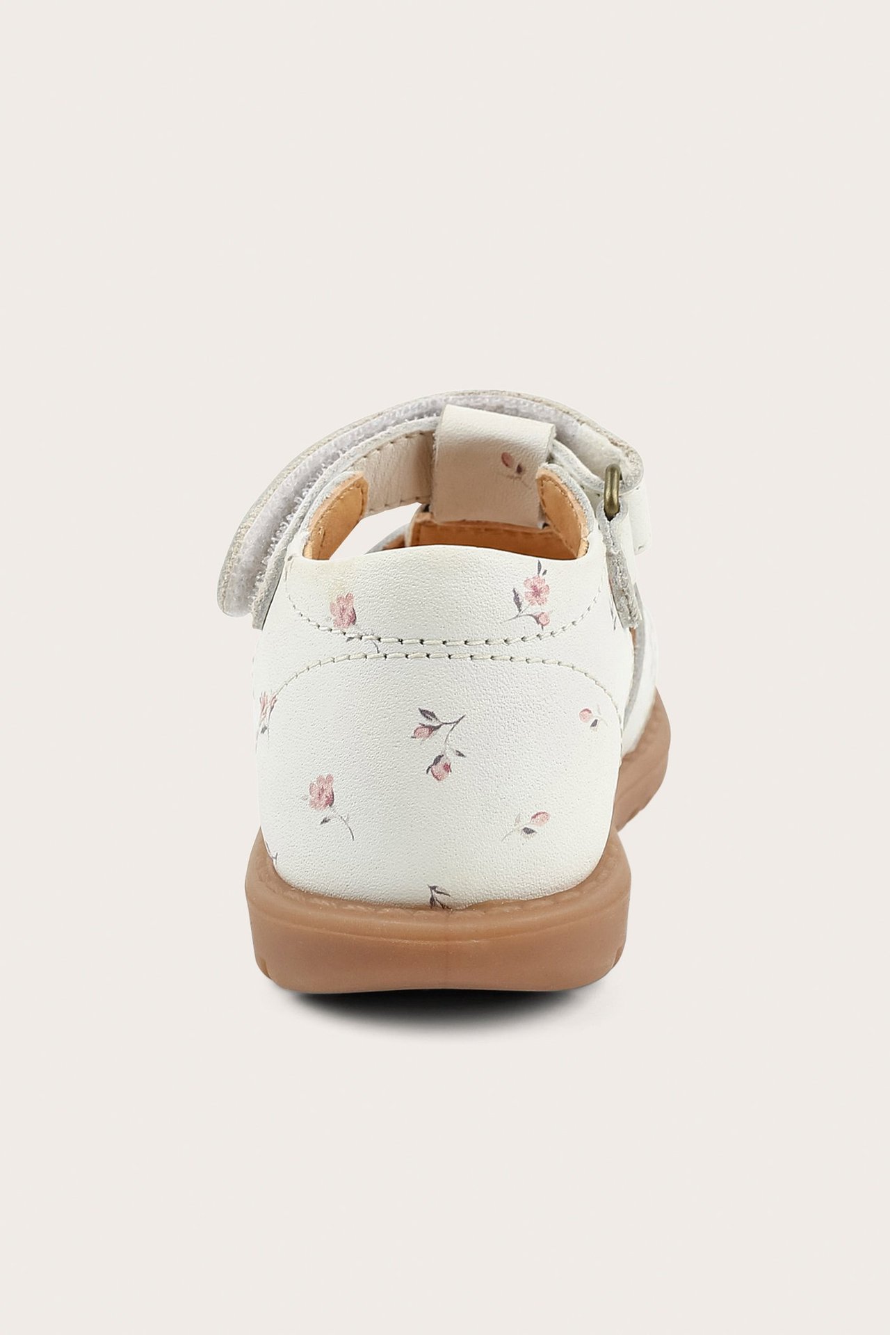 Back view of white kid's leather sandal with small pink flowers, Velcro strap, brown sole.
