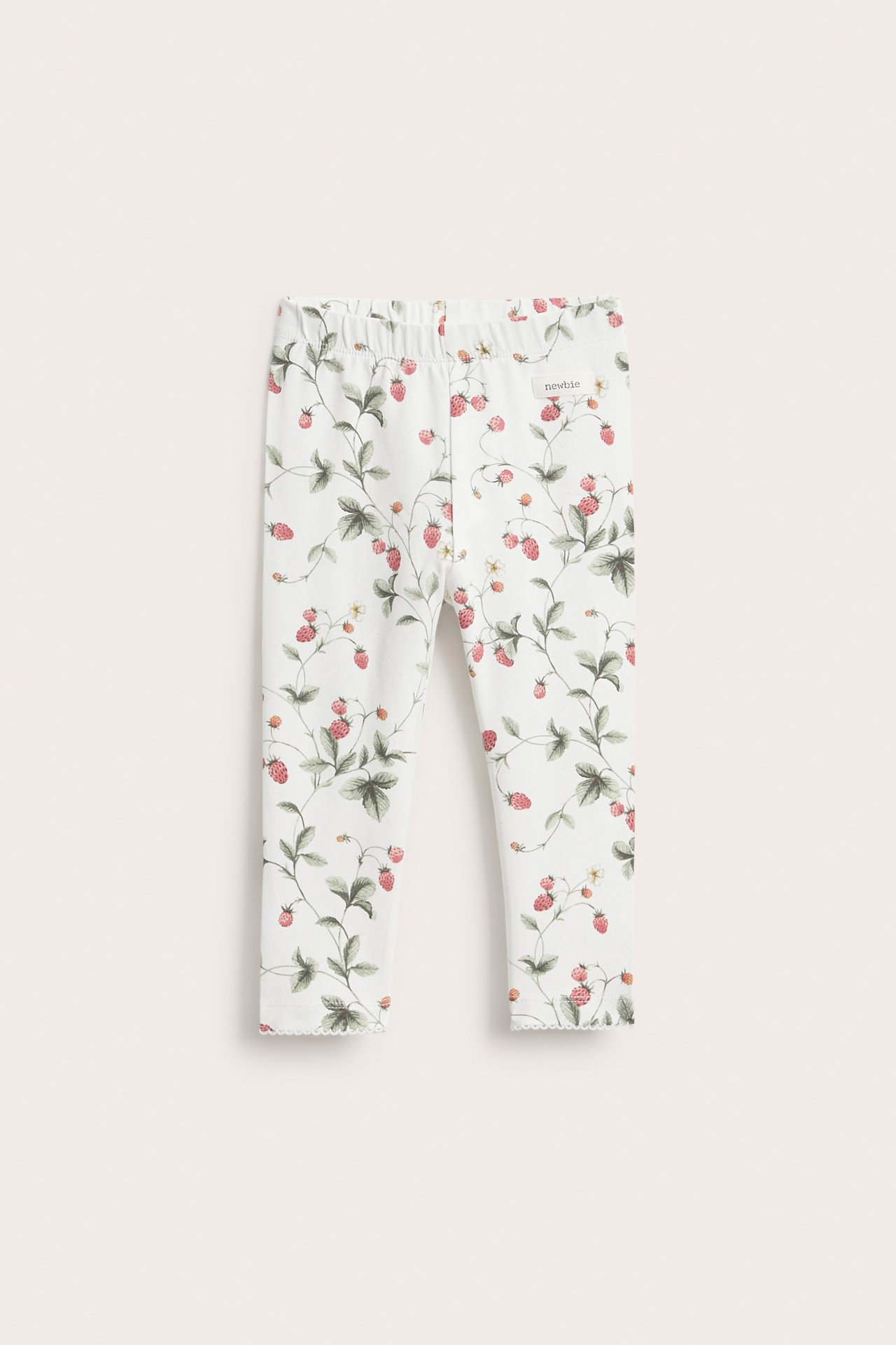 Frontansicht: Off-white Jersey-Leggings für Kinder mit rotem Erdbeer- und grünem Blättermuster, Gummibund und Picot-Saum.