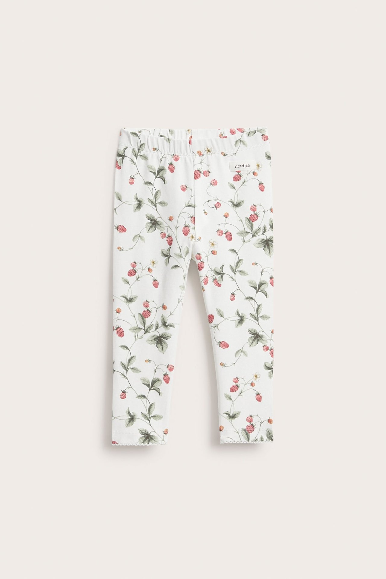 Frontansicht: Off-white Jersey-Leggings für Kinder mit rotem Erdbeer- und grünem Blättermuster, Gummibund und Picot-Saum.