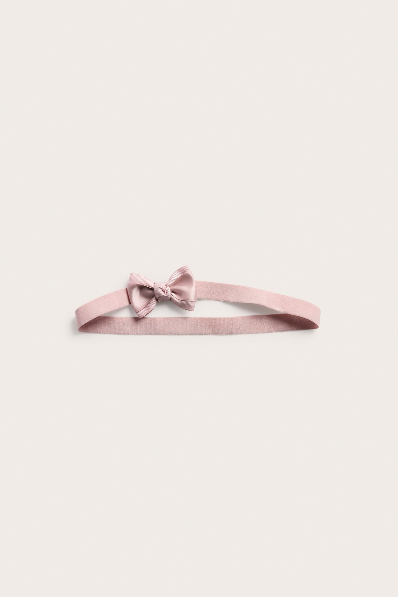 Light pink headband with a double satin bow at the front, shown in front view.