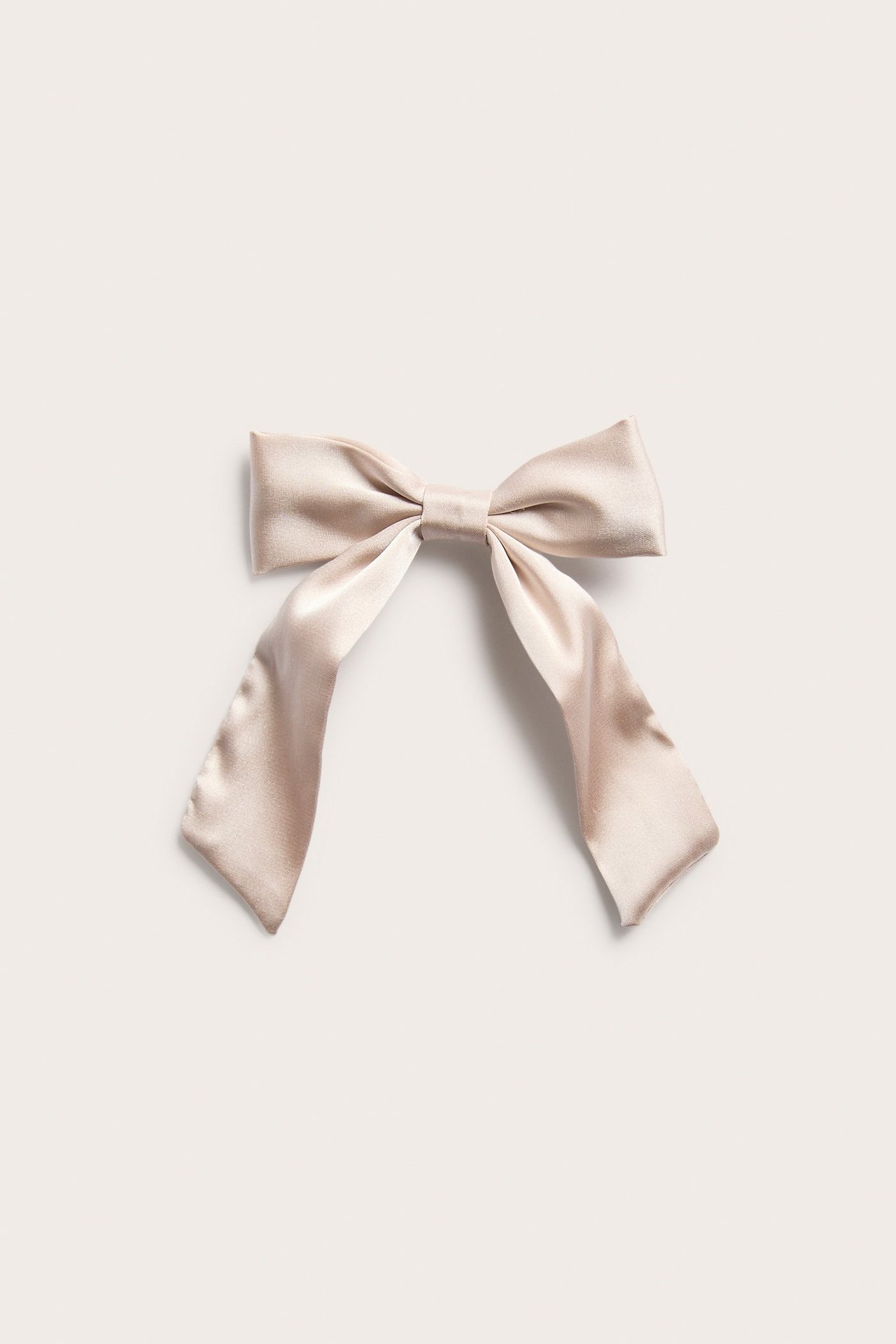 Front view of a light pink satin bow hair clip with a metal fastening.