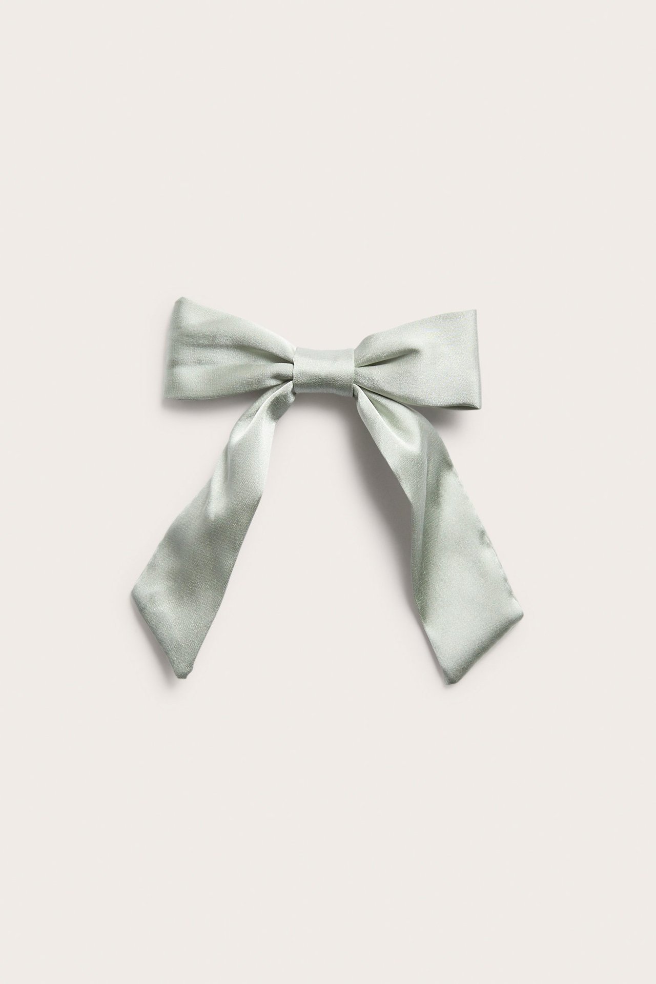 Front view of a light green satin bow hair clip with a metal fastening.