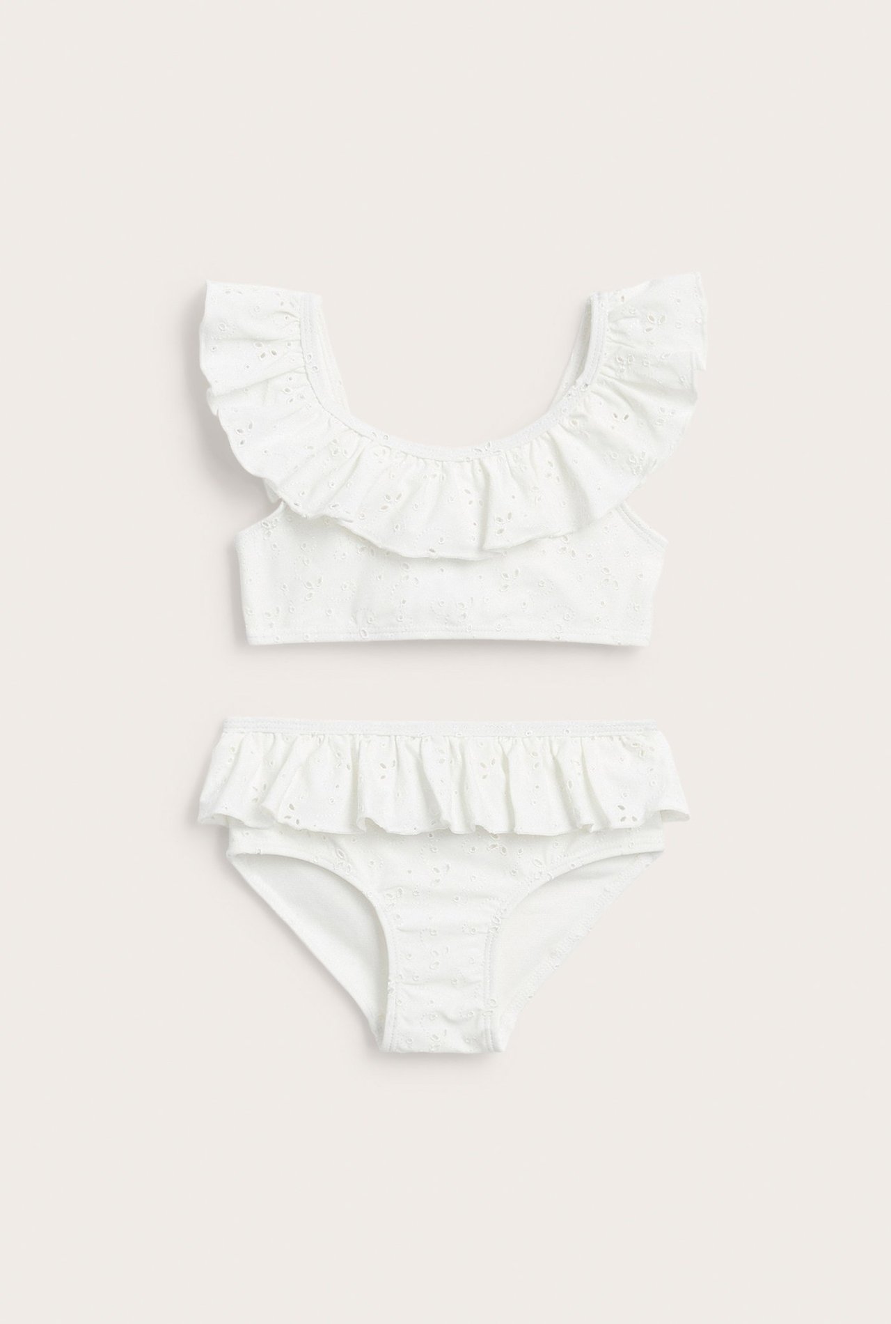 Front view: Off-white kid's bikini set with ruffled top and bottom, featuring eyelet embroidery.