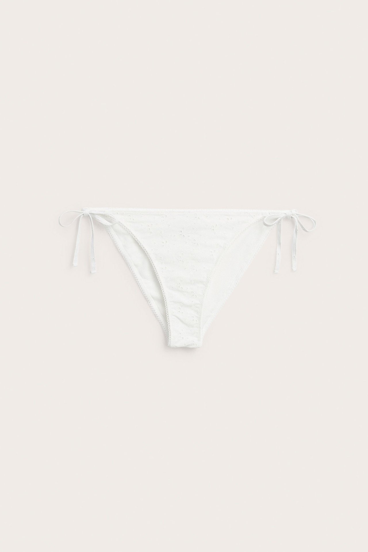 Front view of offwhite women's bikini bottoms with all-over embroidery and tie sides.
