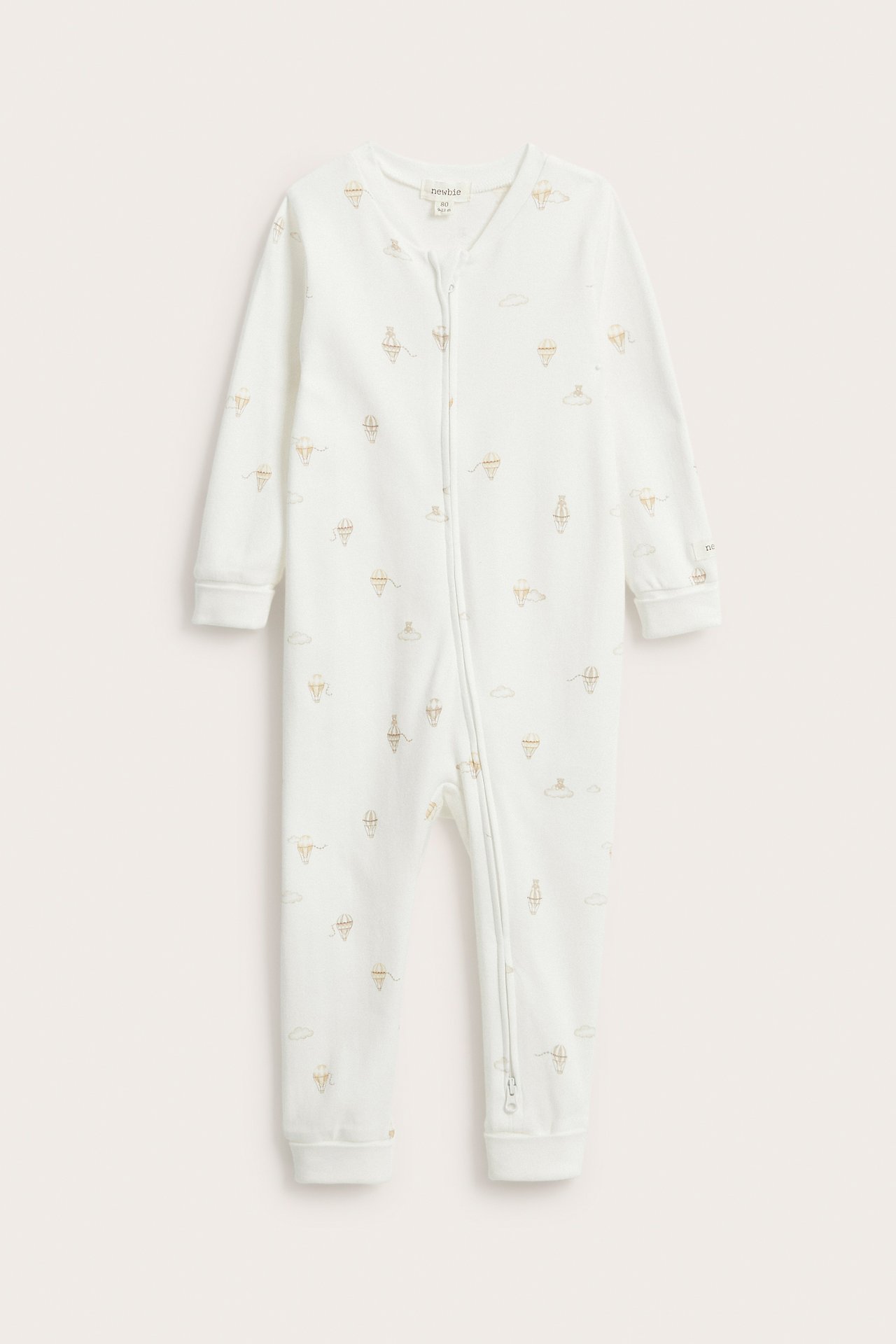 Front view: Off-white baby cotton romper with a hot air balloon pattern and front zipper.