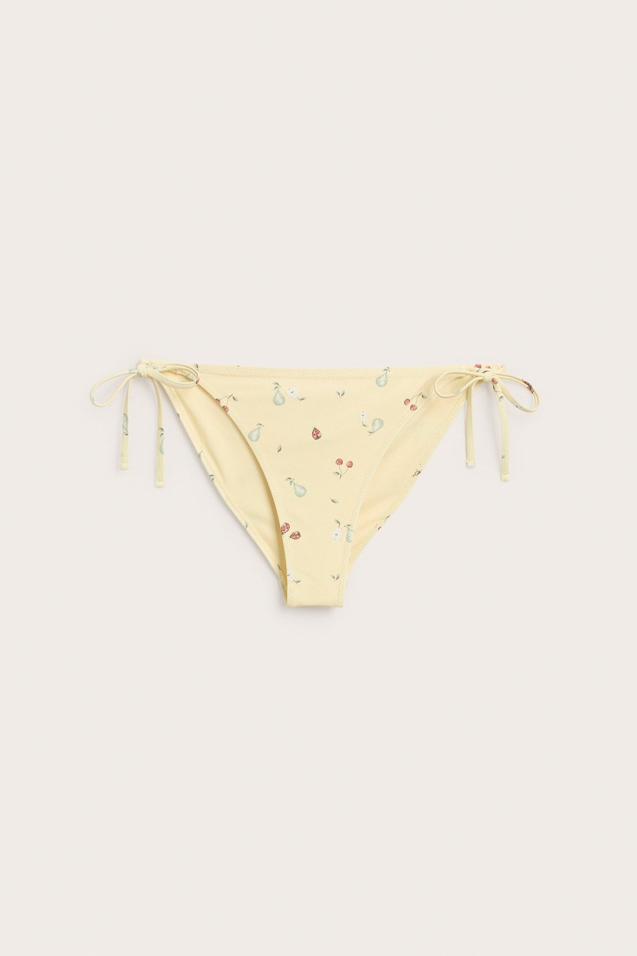 Front view of a yellow women's bikini bottom with a fruit pattern and tie sides.