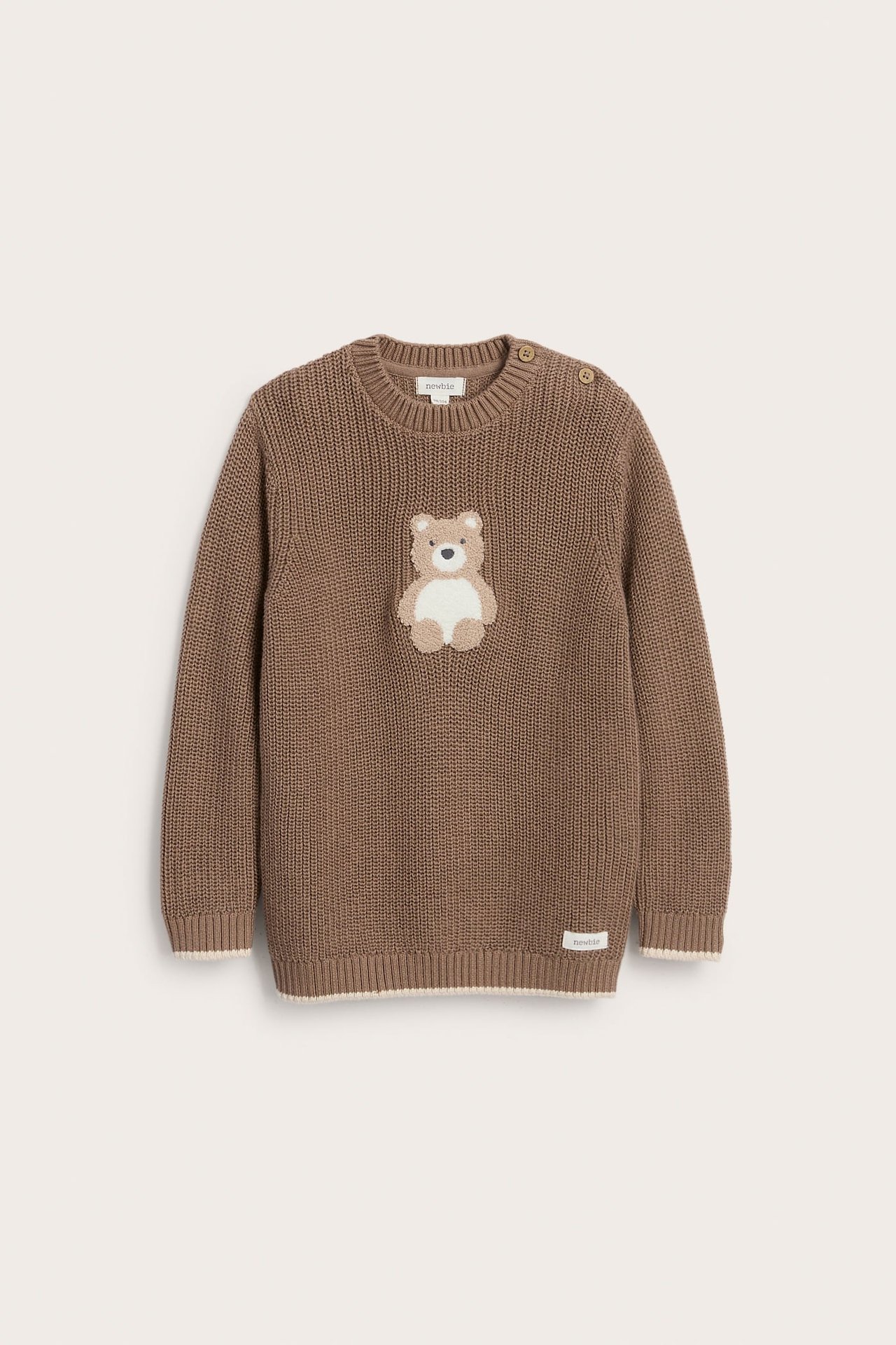 Vorderansicht eines braunen gestrickten Babypullovers mit Teddy-Applikation und Schulterknöpfen.
