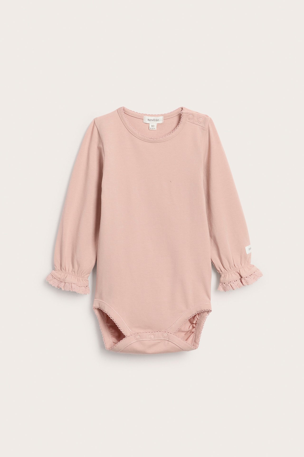 Vorderansicht eines rosa langärmeligen Babybodys mit Spitzenbesatz und Druckknöpfen.