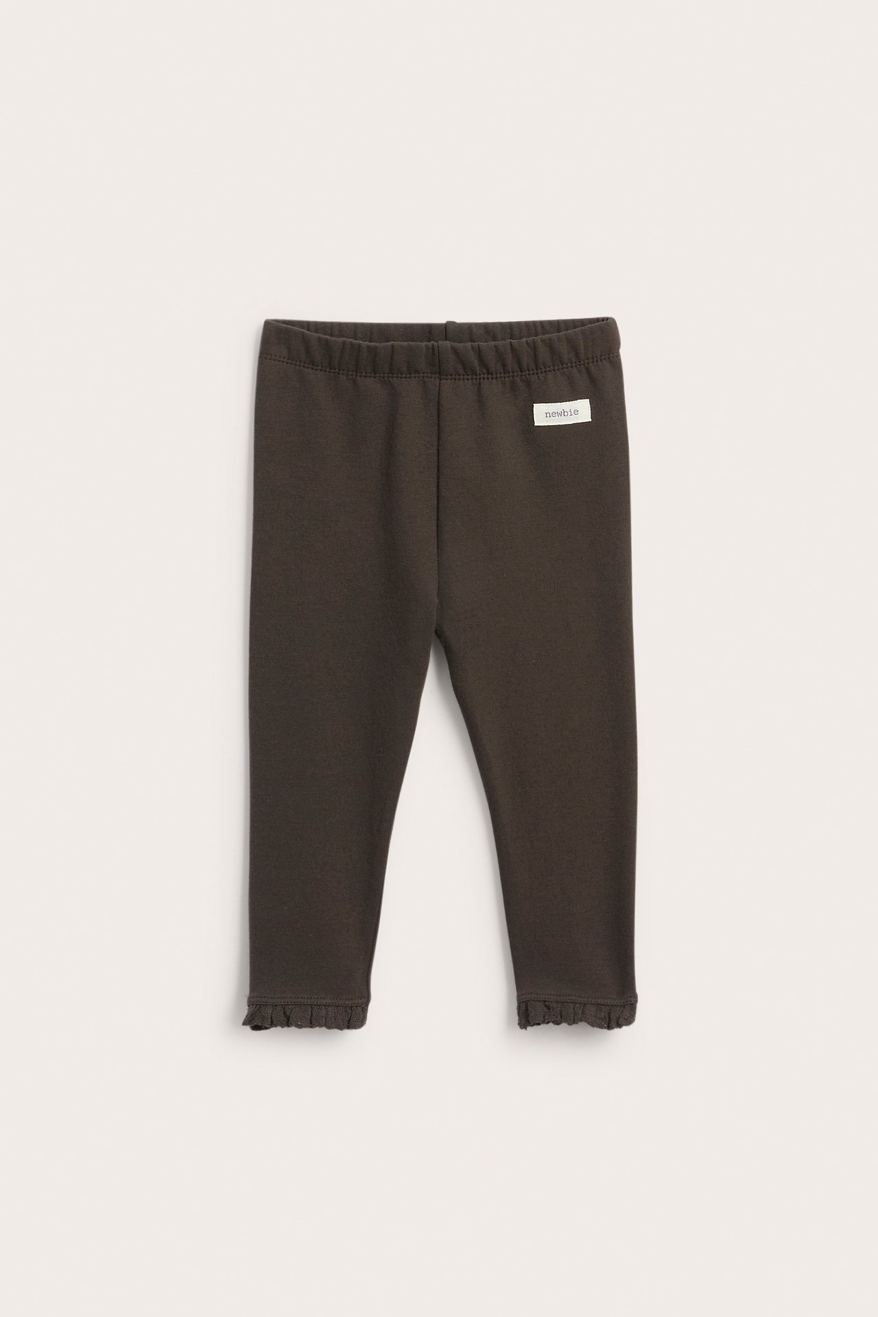 Front view of dark brown baby leggings with an elastic waistband and ruffled hems.