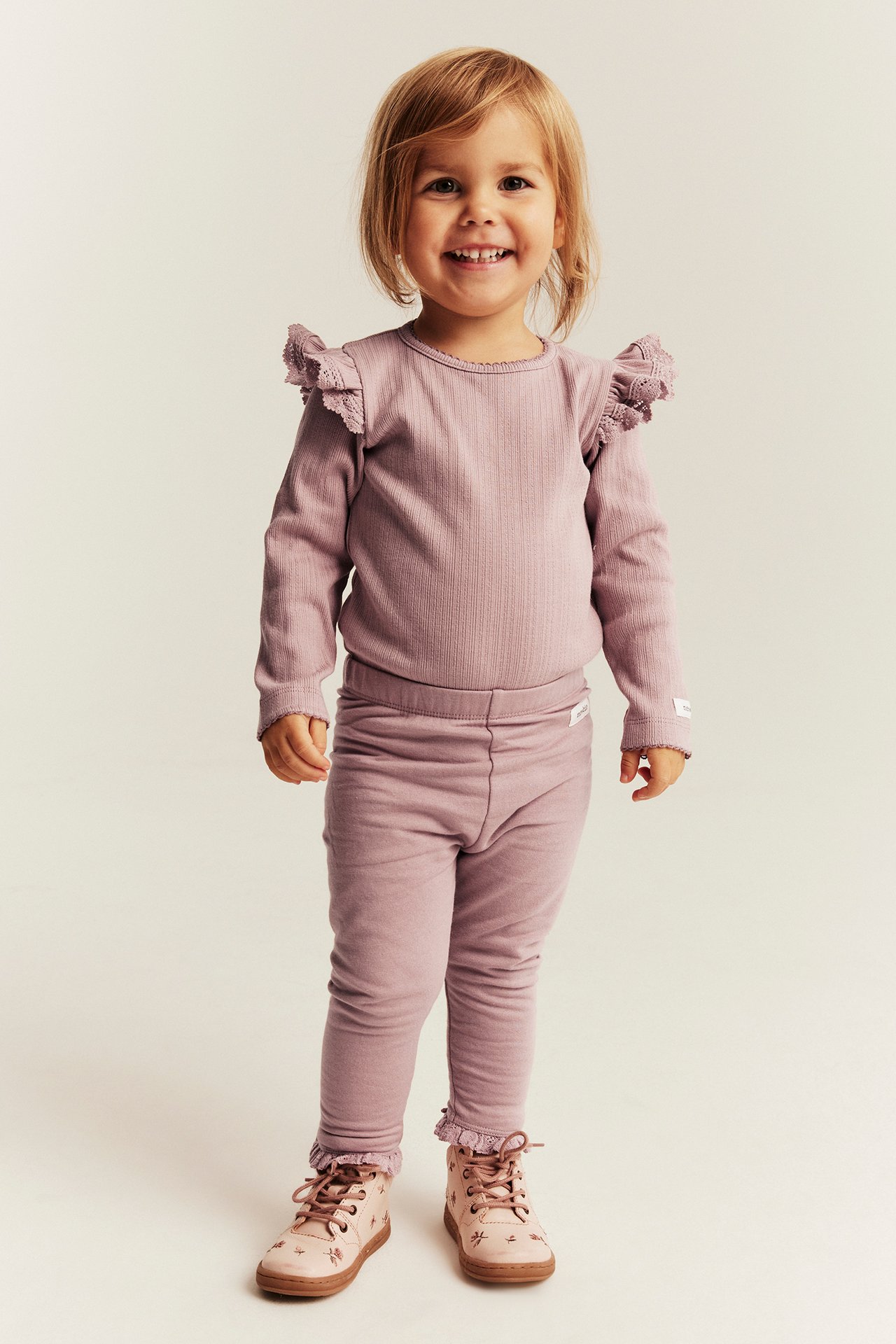 Kinder-Mauve-rosa geripptes Langarmshirt mit Schulterrüschen, passenden Leggings und rosa Stiefeln.
