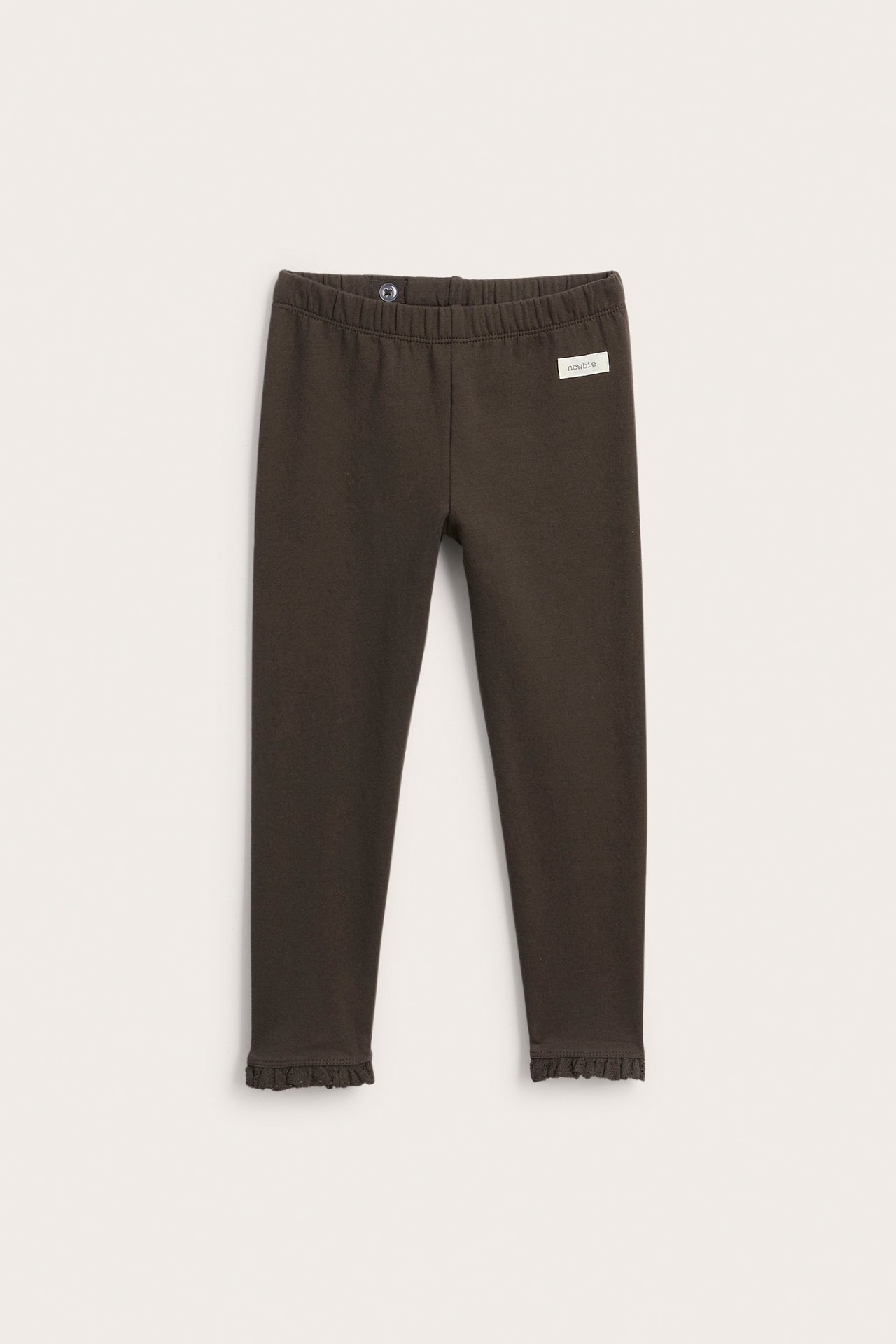 Vorderansicht von dunkelbraunen Kinderleggings mit Gummizug, Knopf und Rüschenbündchen.