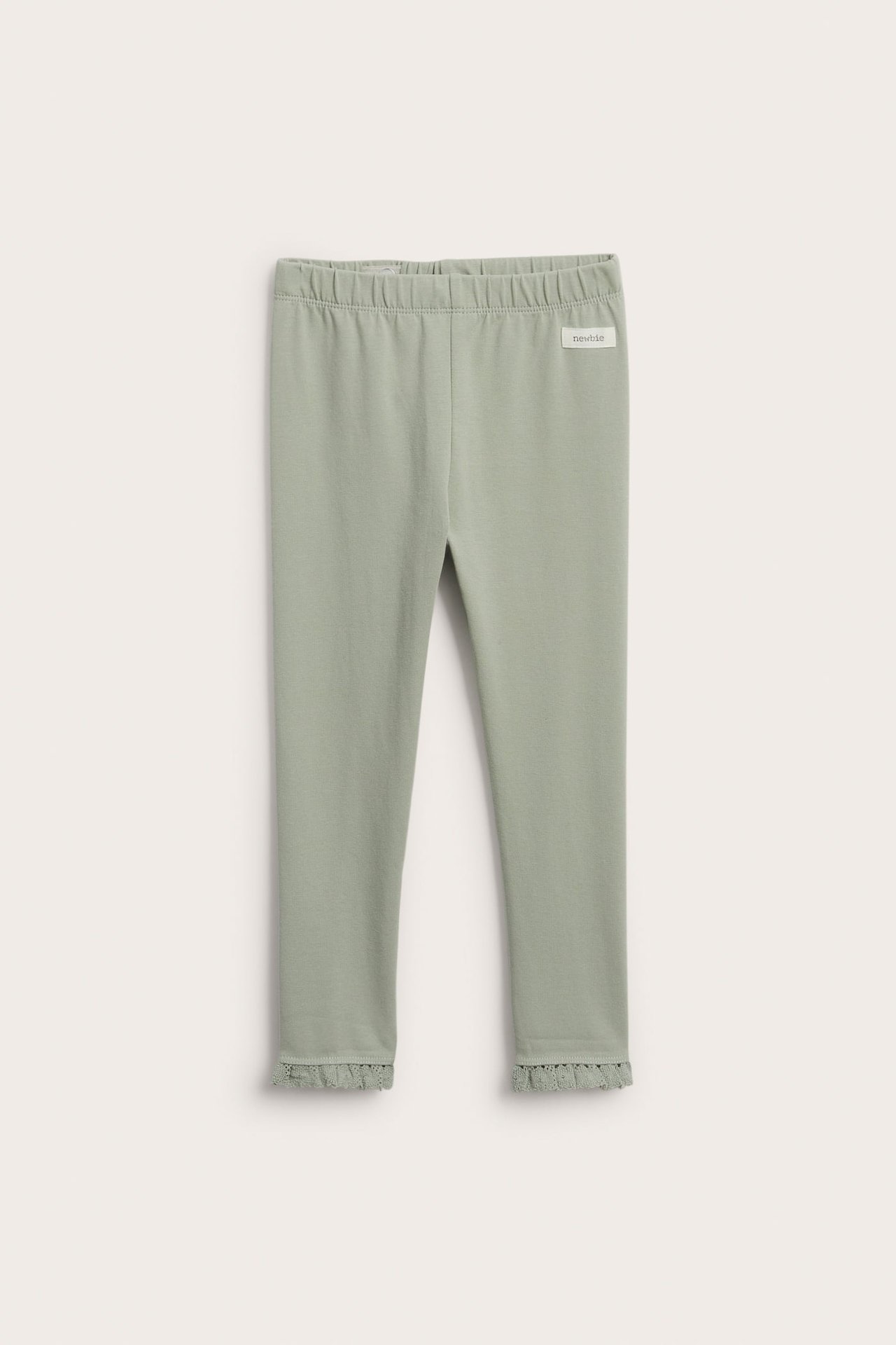 Vorderansicht von grünen Baumwoll-Mix-Leggings mit Gummibund und Spitzenrüschen an den Knöcheln.