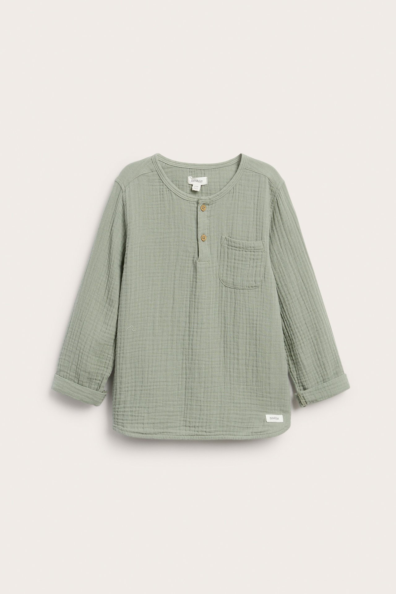 Vorderansicht: Kinder-Langarmshirt aus dunkelgrünem Musselin, Knöpfe, Brusttasche, hochgekrempelte Ärmel.