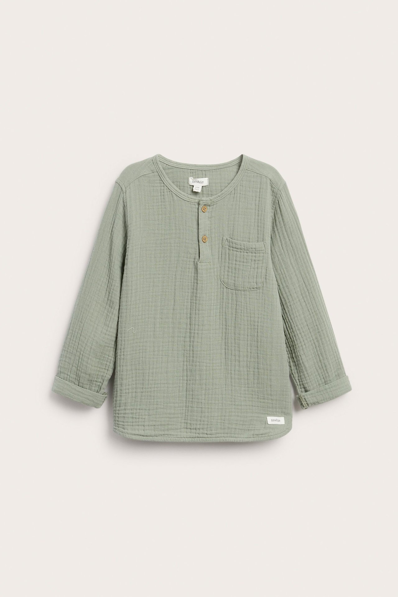 Vorderansicht: Kinder-Langarmshirt aus dunkelgrünem Musselin, Knöpfe, Brusttasche, hochgekrempelte Ärmel.