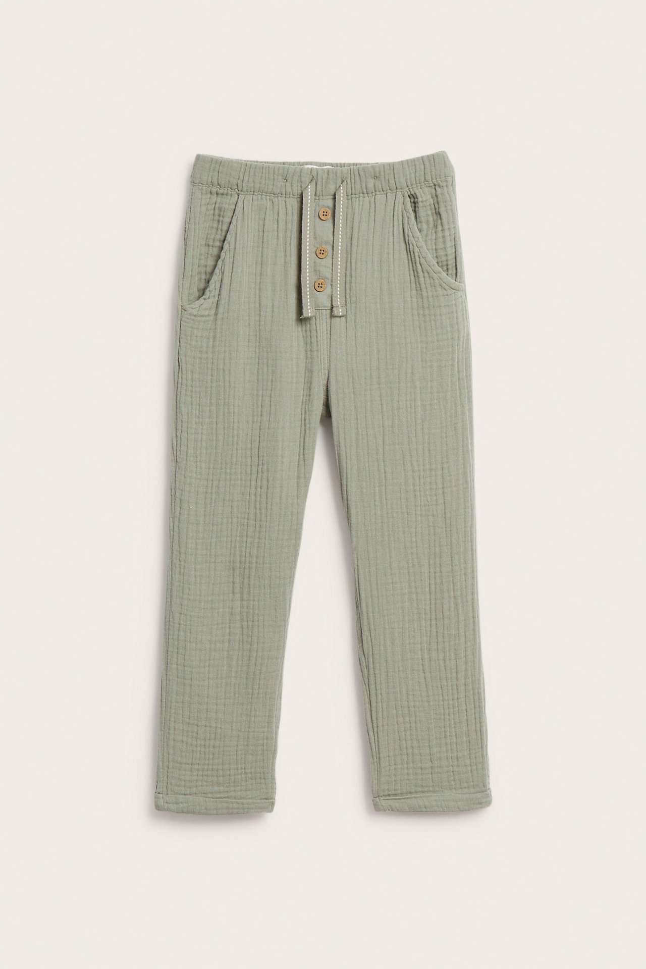 Vorderansicht: Staubgrüne Baumwoll-Musselin-Hose mit Gummizugbund, Zierknöpfen und Taschen.