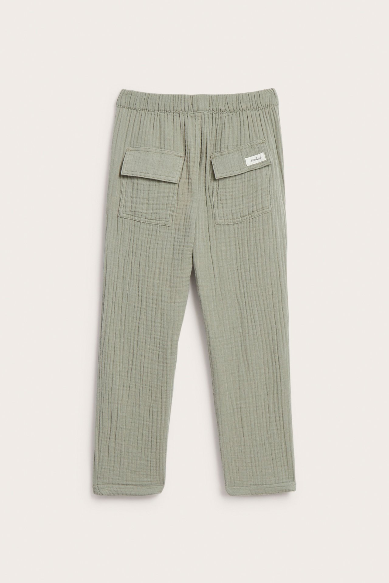 Rückansicht von Kinderhose aus dunkelgrünem Baumwollmusselin mit elastischem Bund und zwei Pattentaschen hinten.