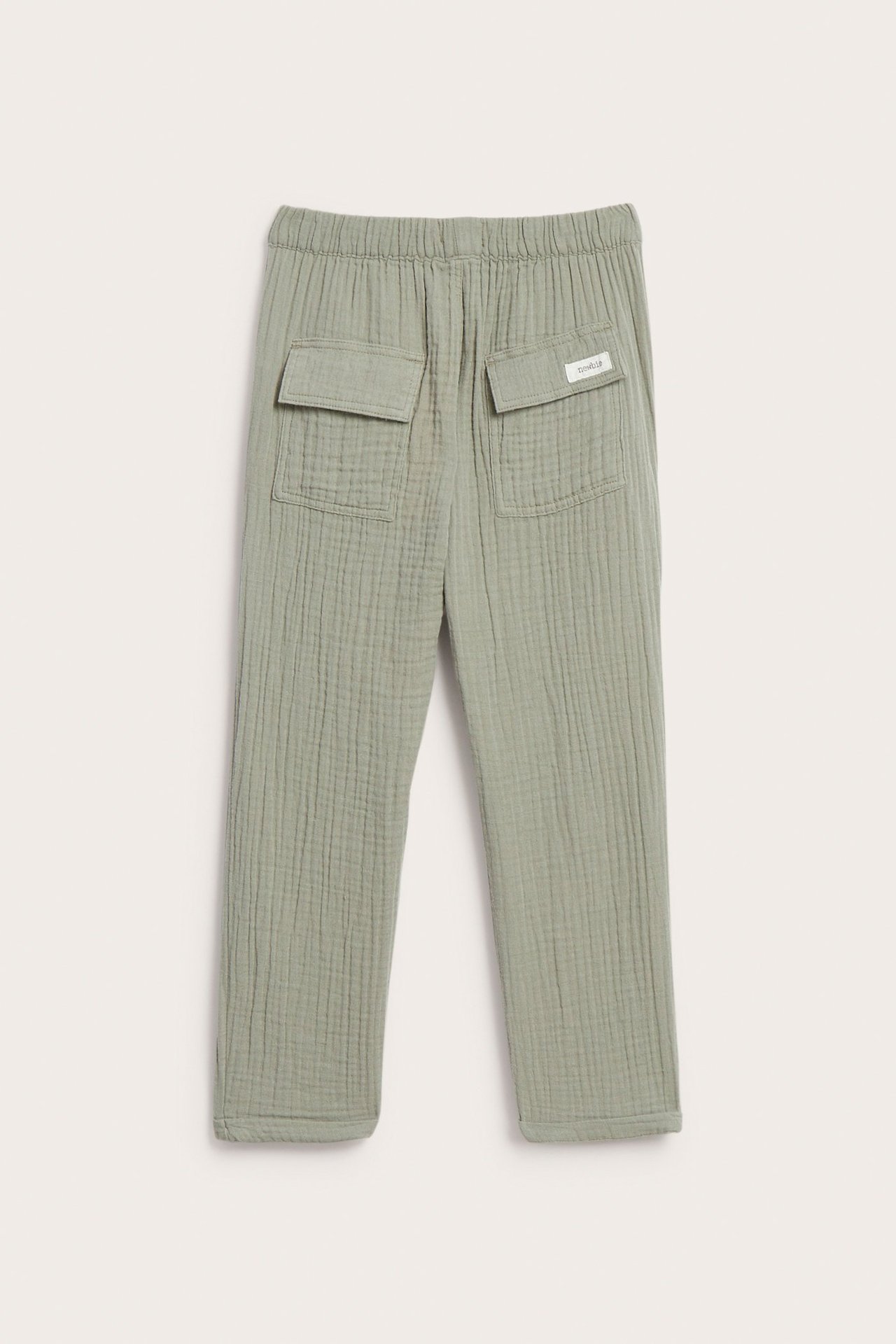 Rückansicht von Kinderhose aus dunkelgrünem Baumwollmusselin mit elastischem Bund und zwei Pattentaschen hinten.